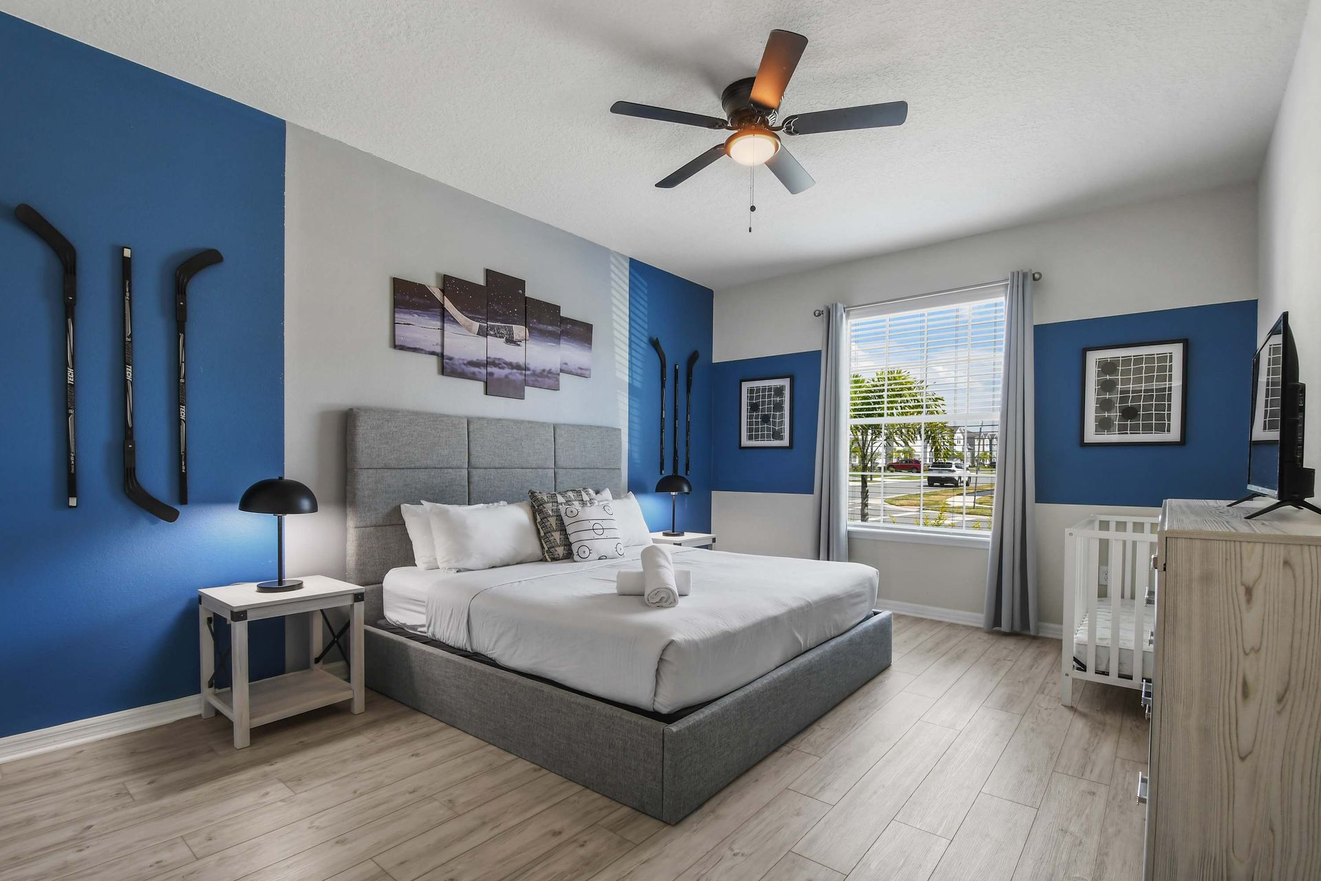 Hockey-themed bedroom with modern decor, cozy bedding, and natural light.