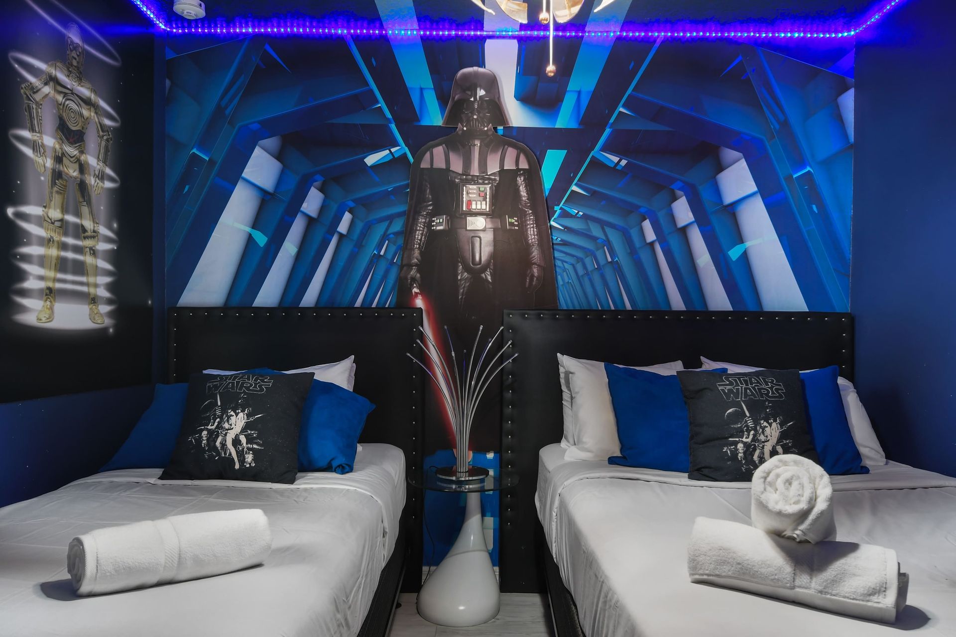 Space-themed room with twin beds, glowing LED lights, and epic galactic decor.