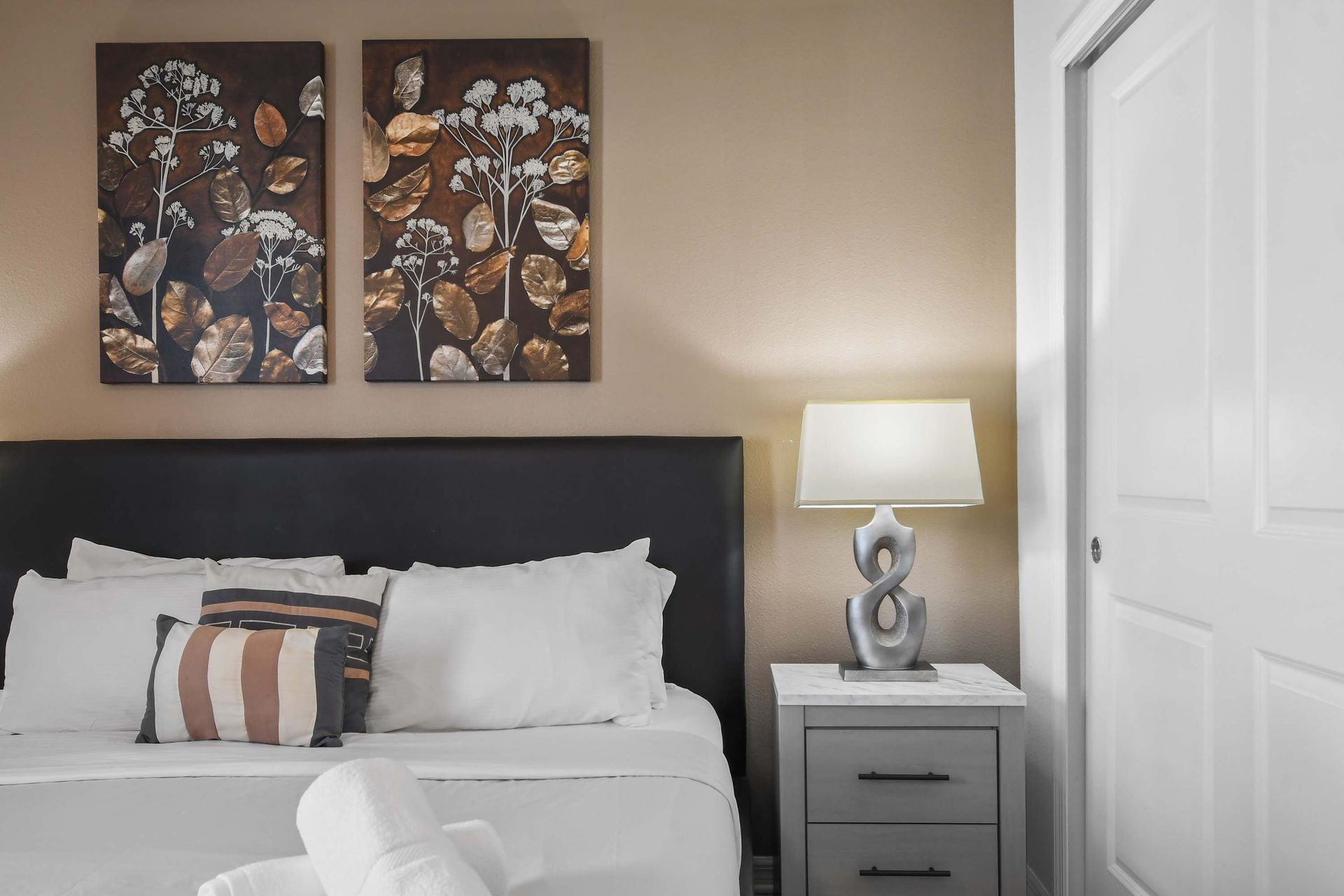 Modern bedroom with warm tones, elegant decor, and a comfortable king bed.