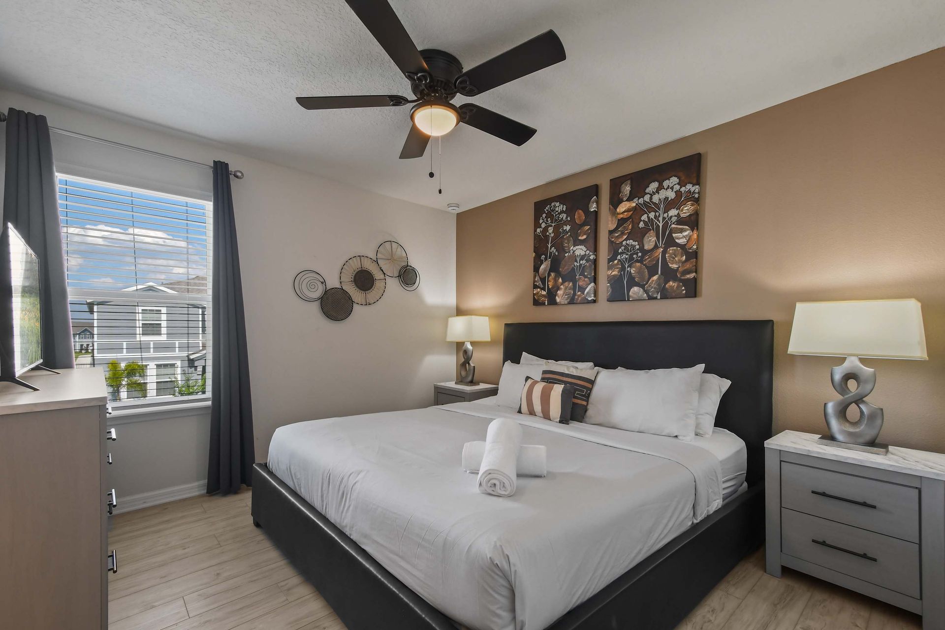 Modern bedroom with warm tones, elegant decor, and a comfortable king bed.