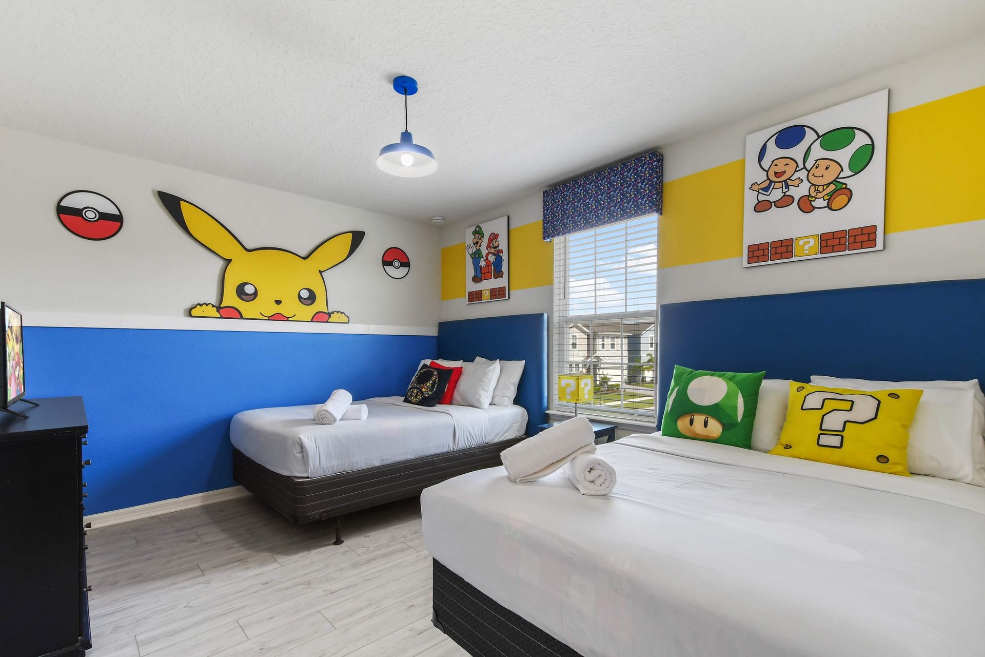 Playful gaming-themed room with bright decor, twin beds, and vibrant accents.