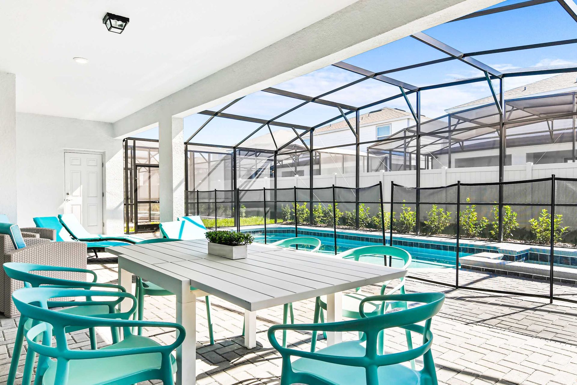 Spacious screened-in patio with pool, lounge chairs, and outdoor dining area.