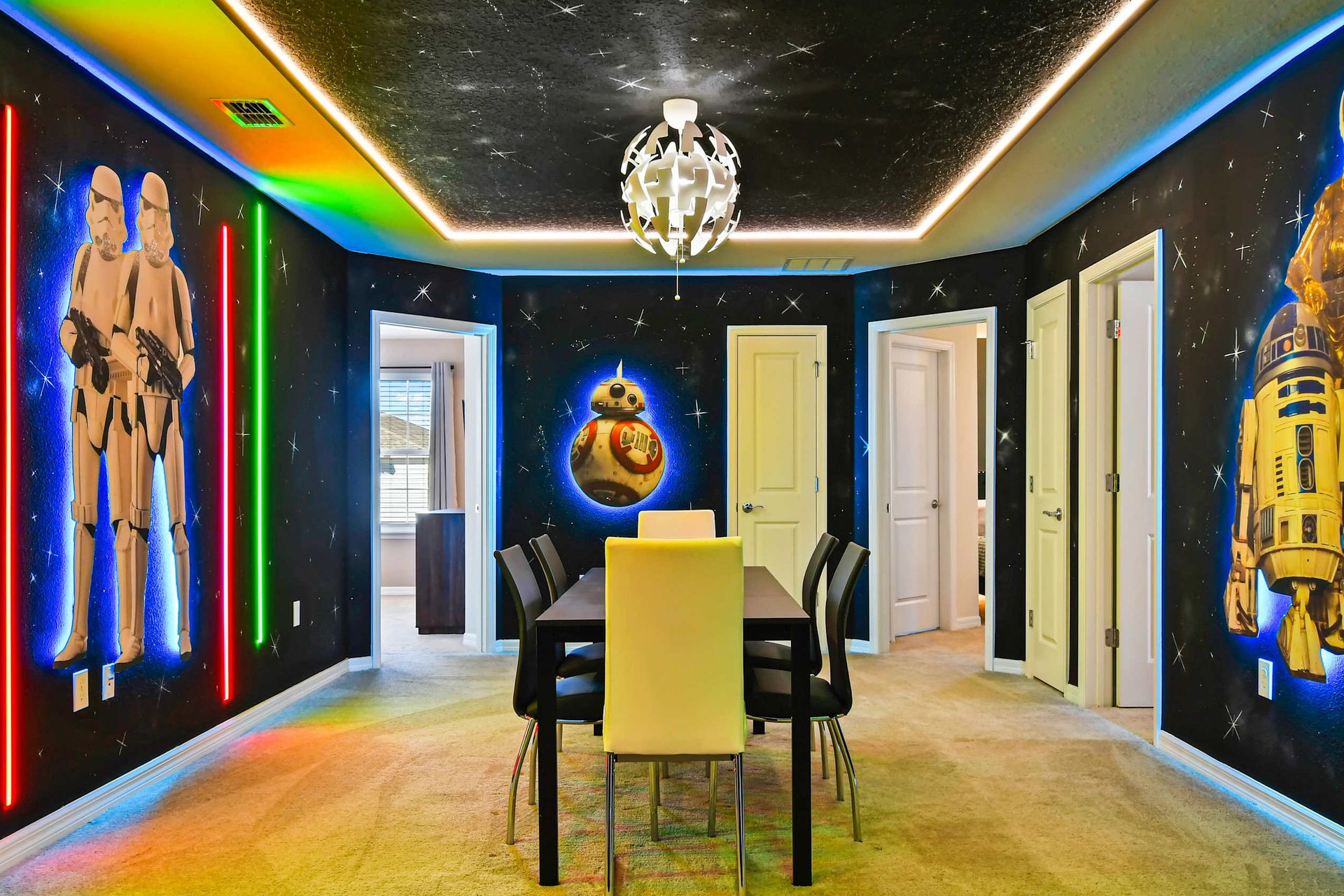 Spacious Star Wars-themed lounge with vivid murals, theater seating, and neon lights.