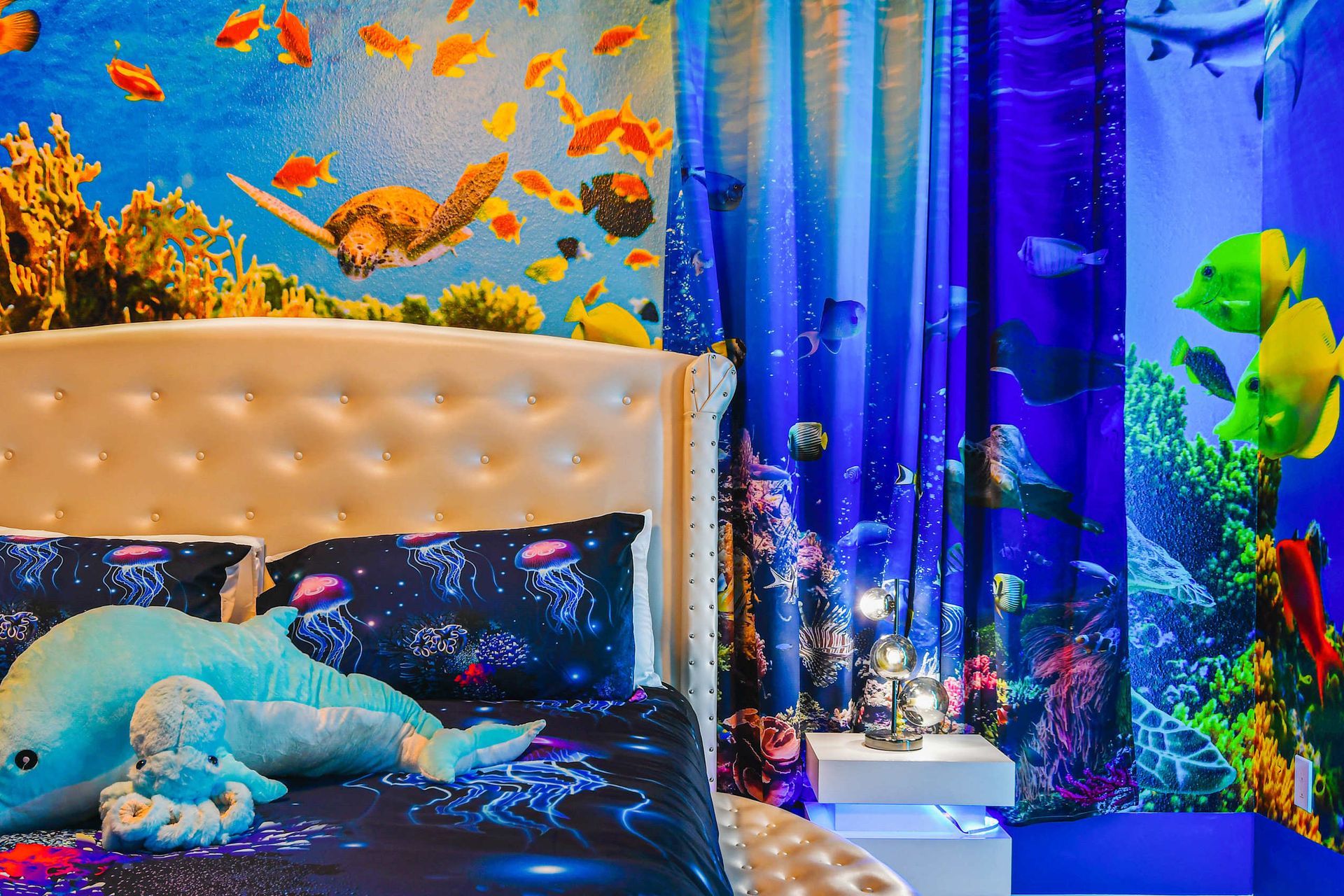 Underwater-themed room with vibrant ocean murals and cozy aquatic bedding.