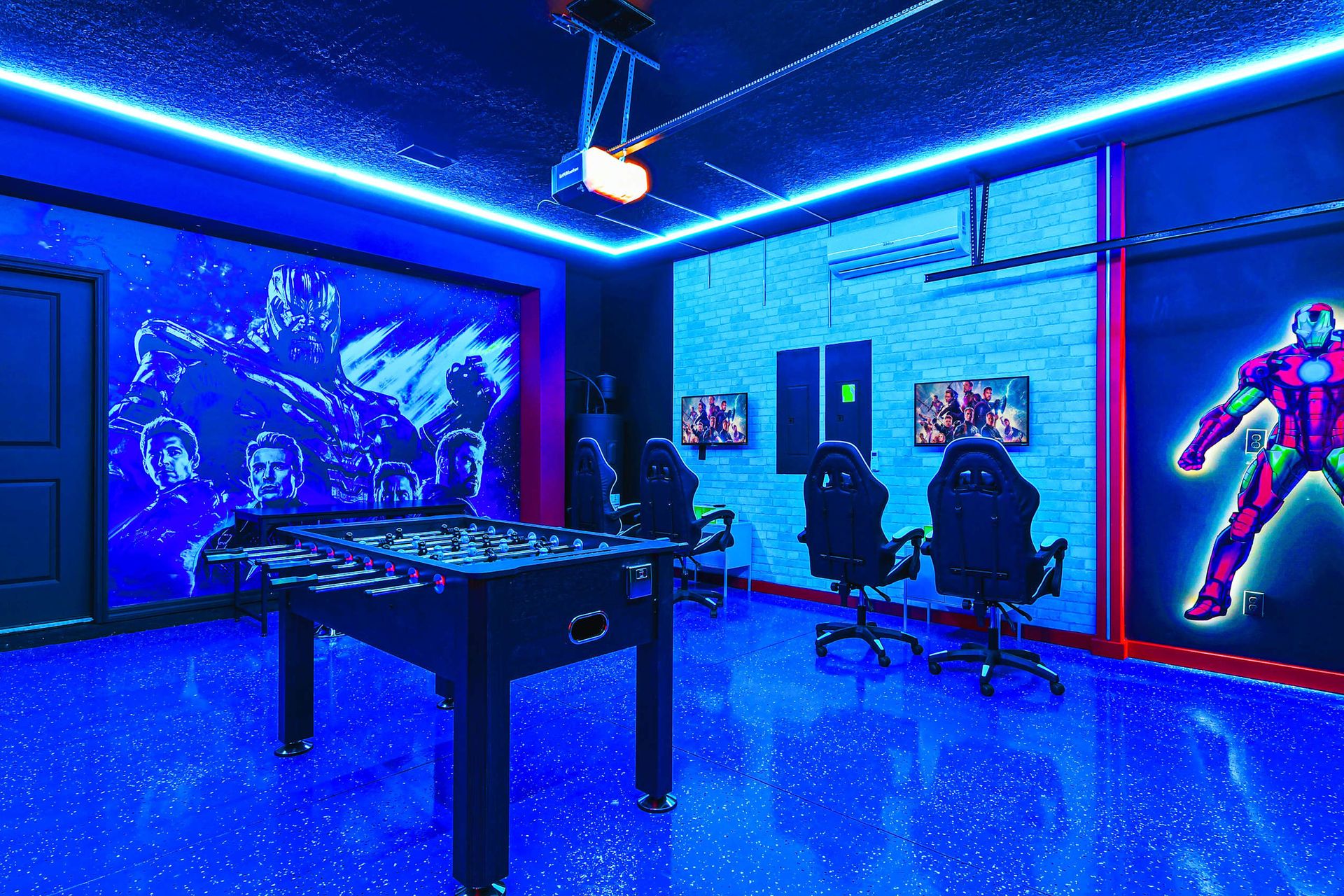 Futuristic Marvel game room with LED lighting, foosball, and gaming stations.