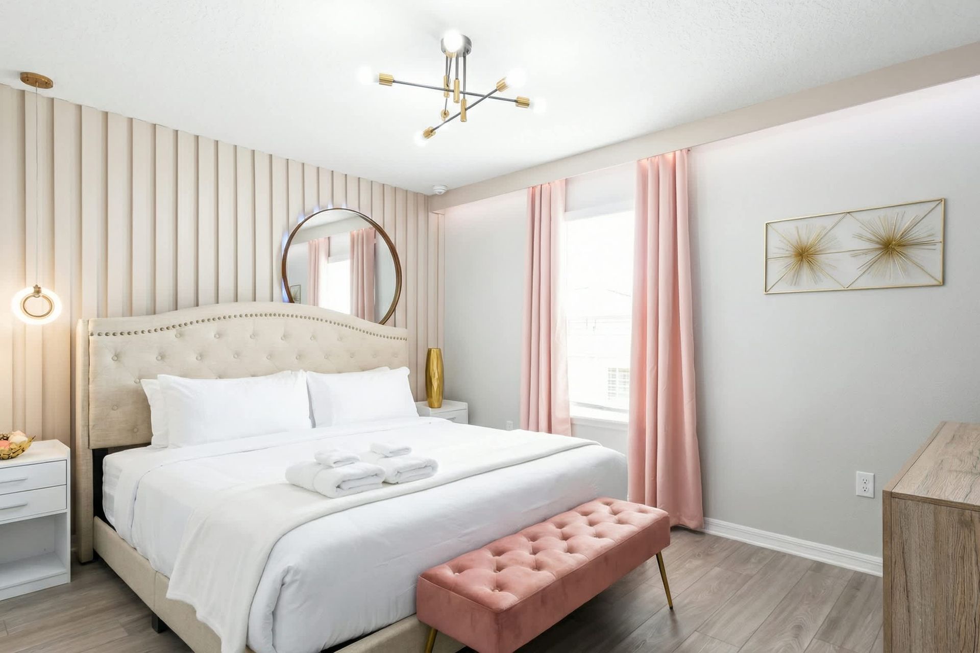 Elegant bedroom with soft pink accents, glam lighting, and a chic romantic vibe.