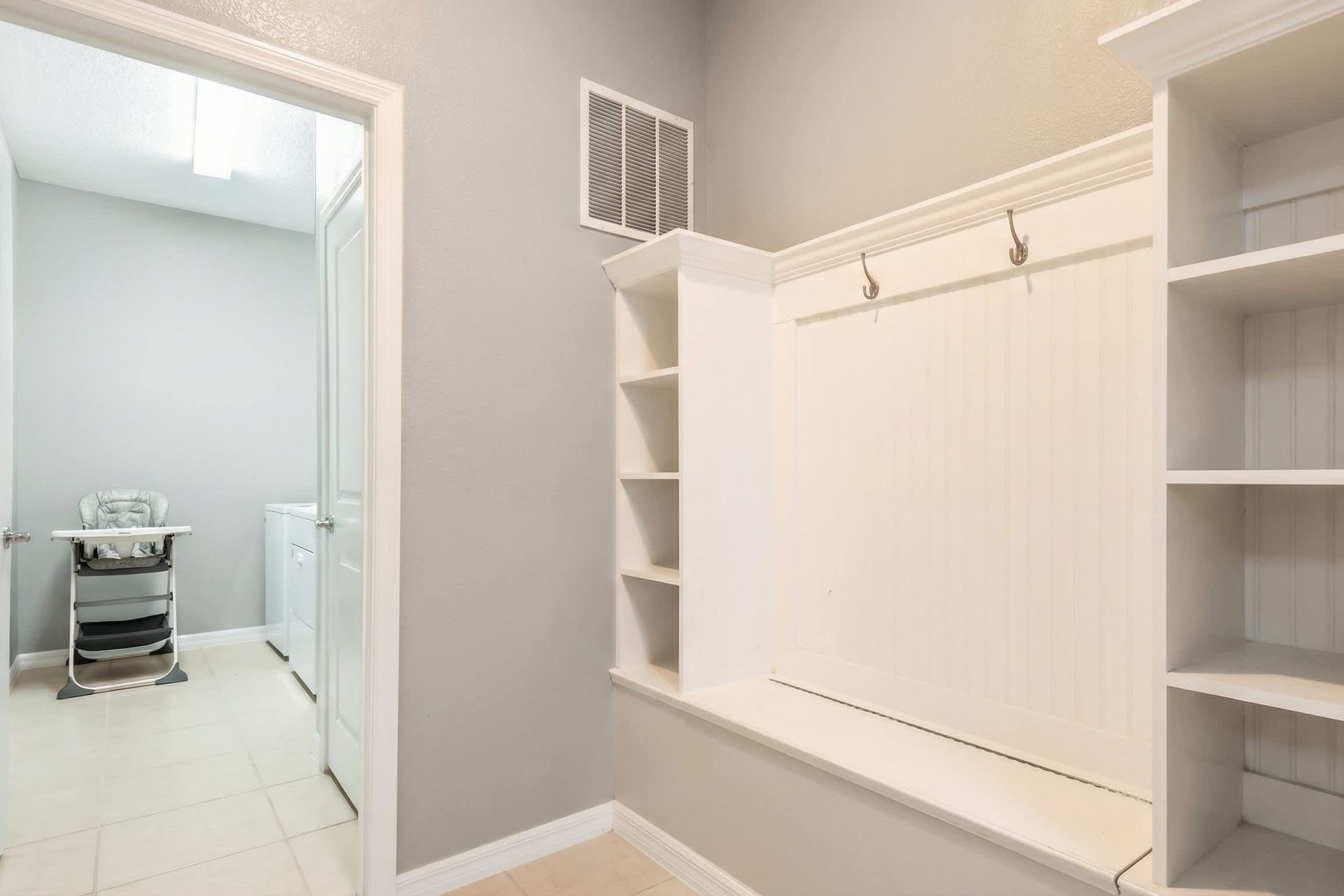 Spacious mudroom with built-in storage and easy access to laundry room.