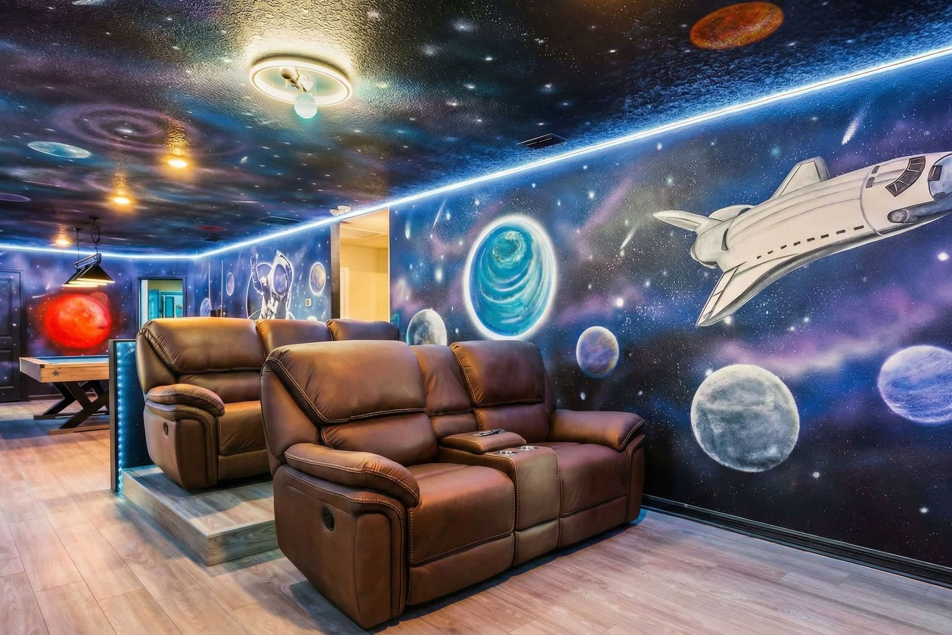 Out-of-this-world theater room with galaxy murals, glowing lights, and plush seating.