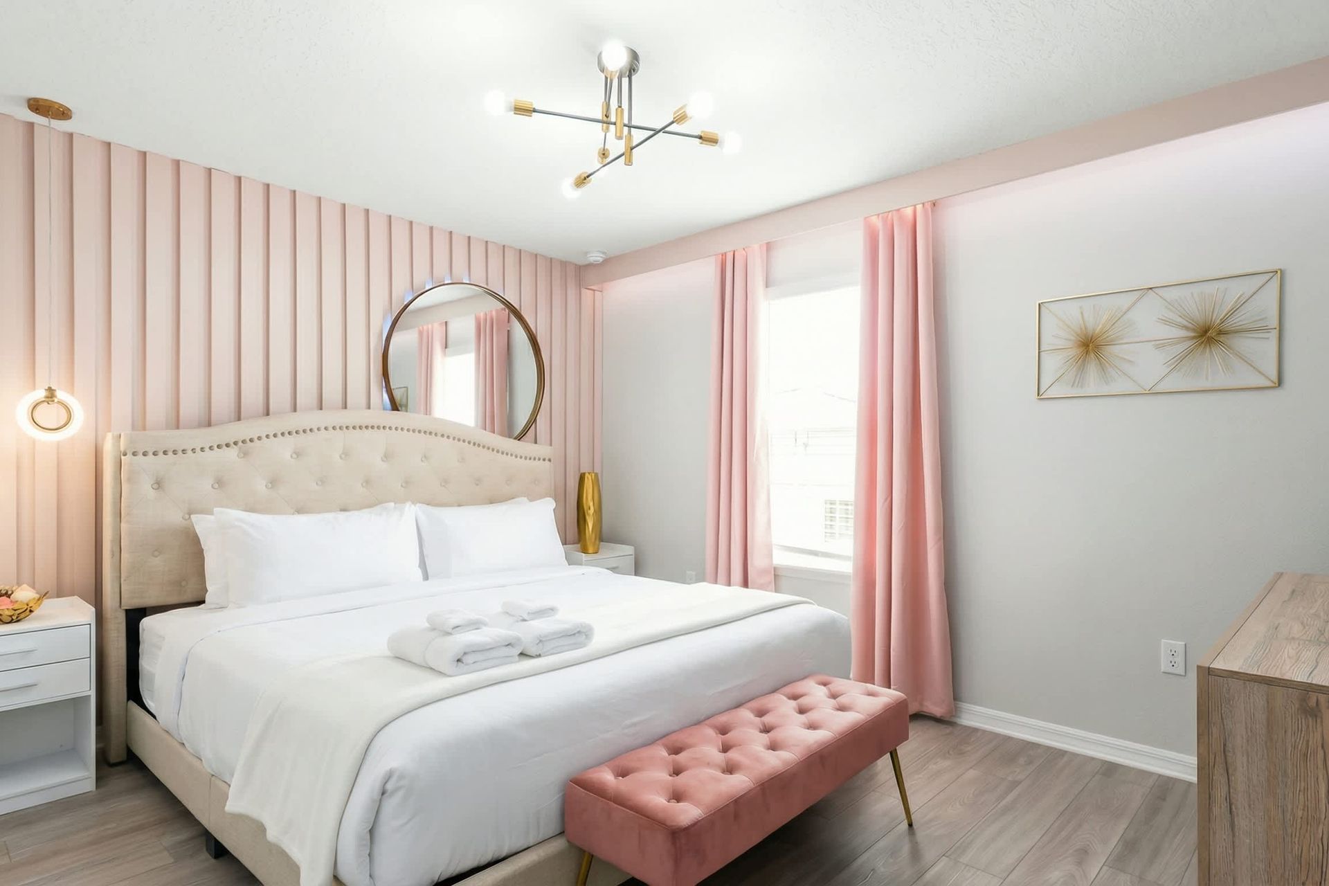 Elegant bedroom with soft pink accents, glam lighting, and a chic romantic vibe.