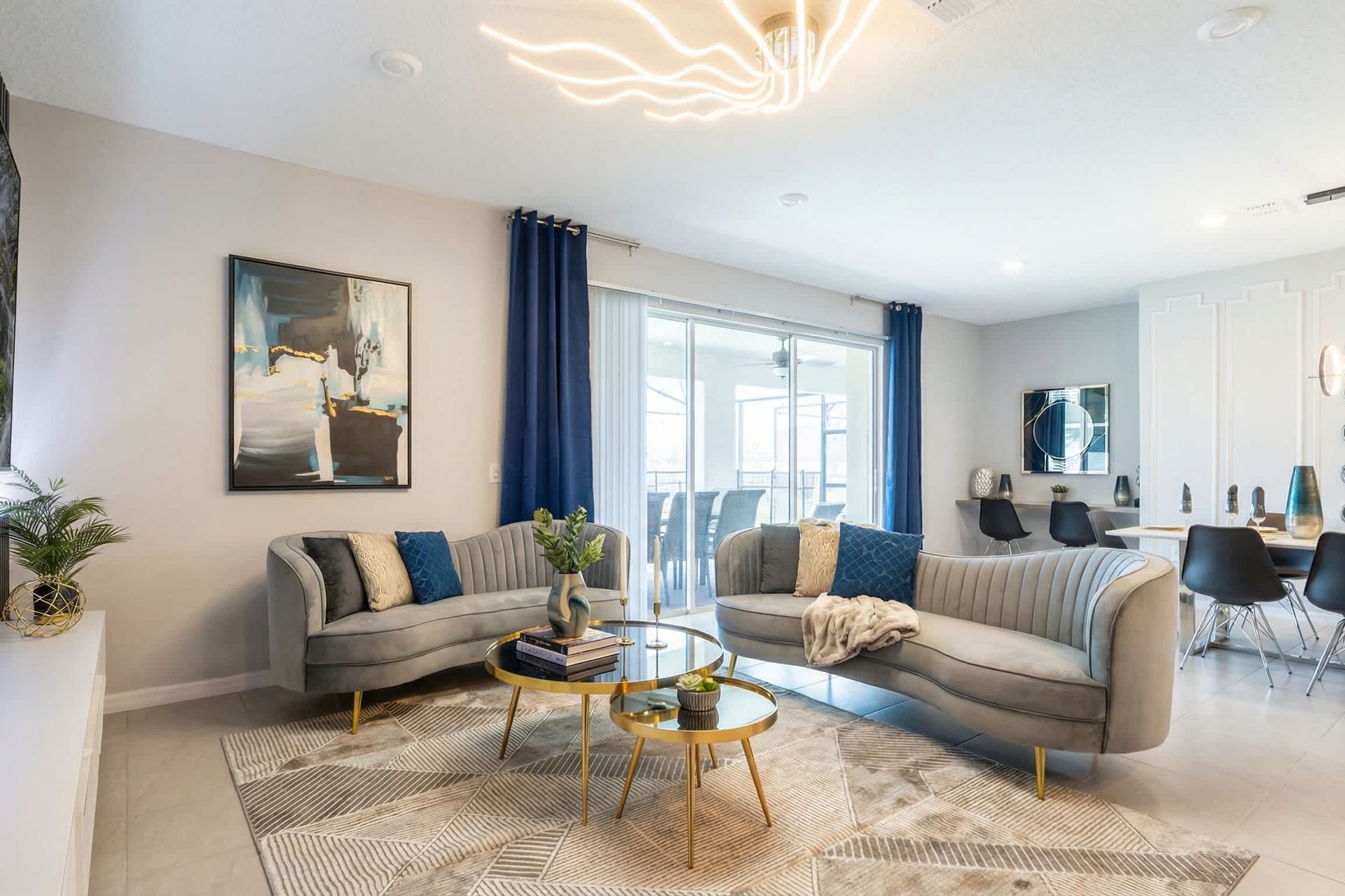 Modern lounge with velvet sofas, gold tables, and seamless indoor-outdoor flow.