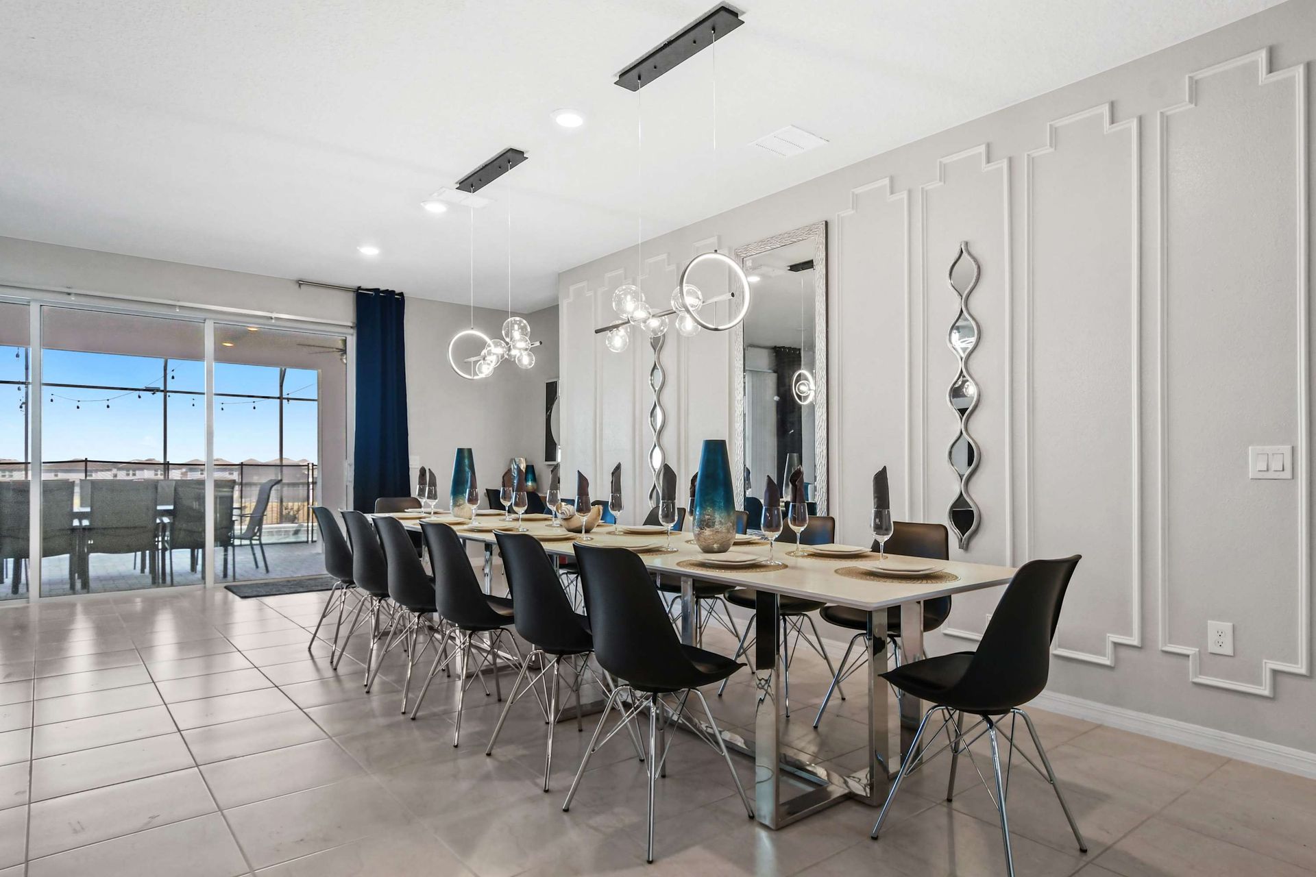 Elegant dining space with seating for 12, modern lighting, and pool views.