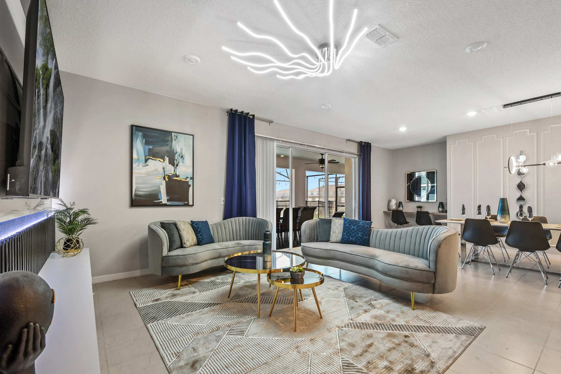 Modern lounge with velvet sofas, gold tables, and seamless indoor-outdoor flow.