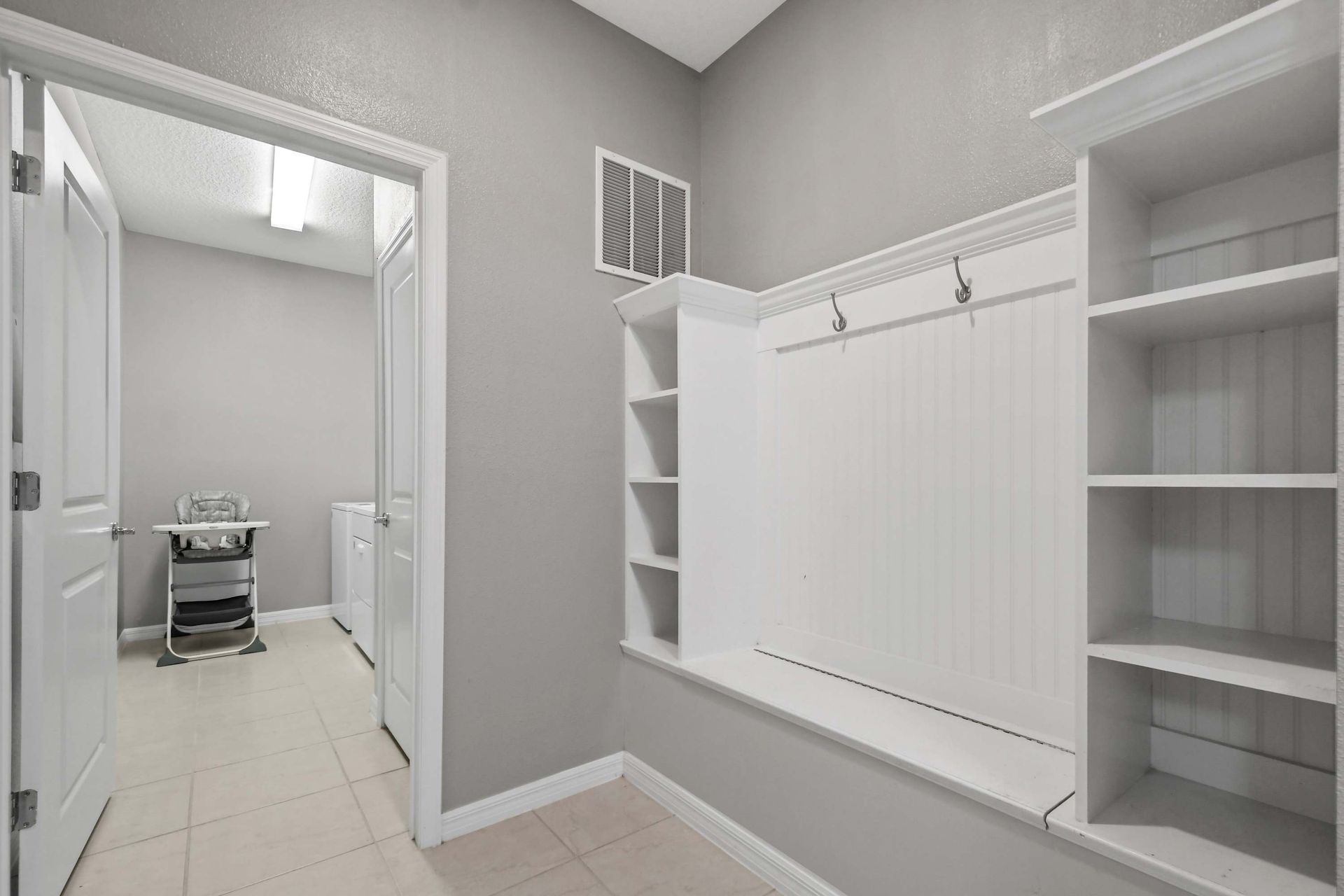 Spacious mudroom with built-in storage and easy access to laundry room.