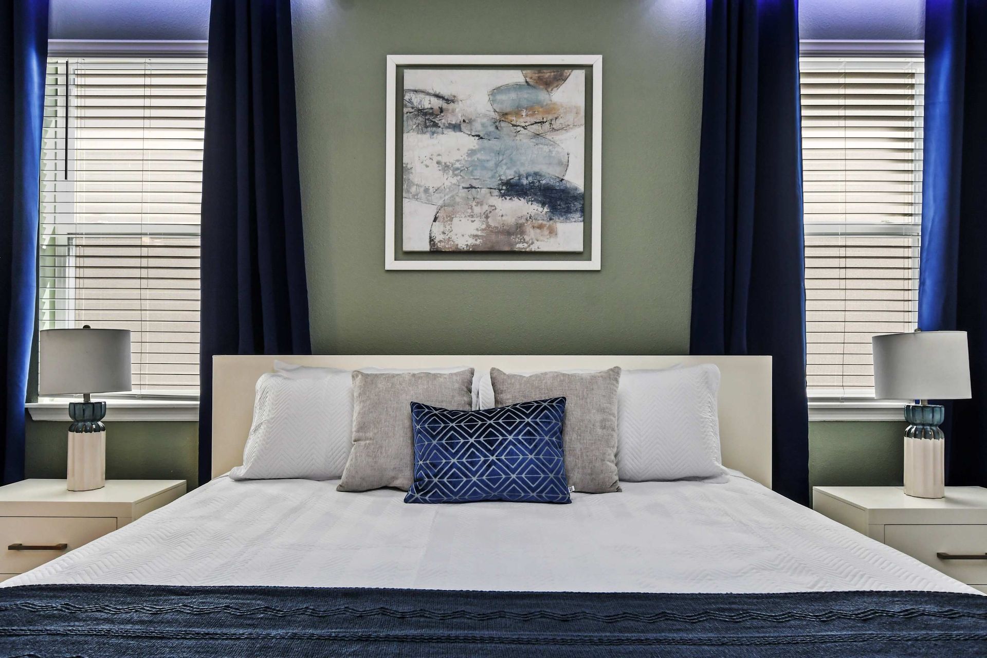 Chic modern bedroom with cozy bedding, elegant lighting, and serene ambiance.