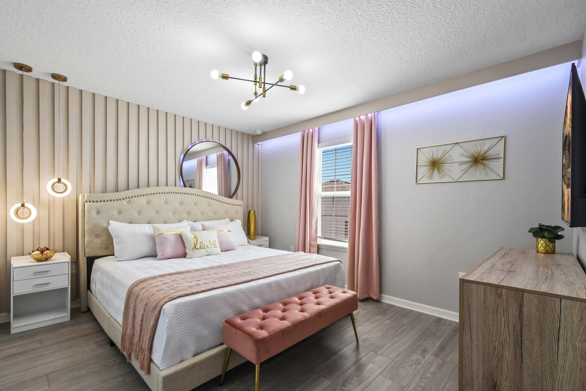 Elegant bedroom with soft pink accents, glam lighting, and a chic romantic vibe.
