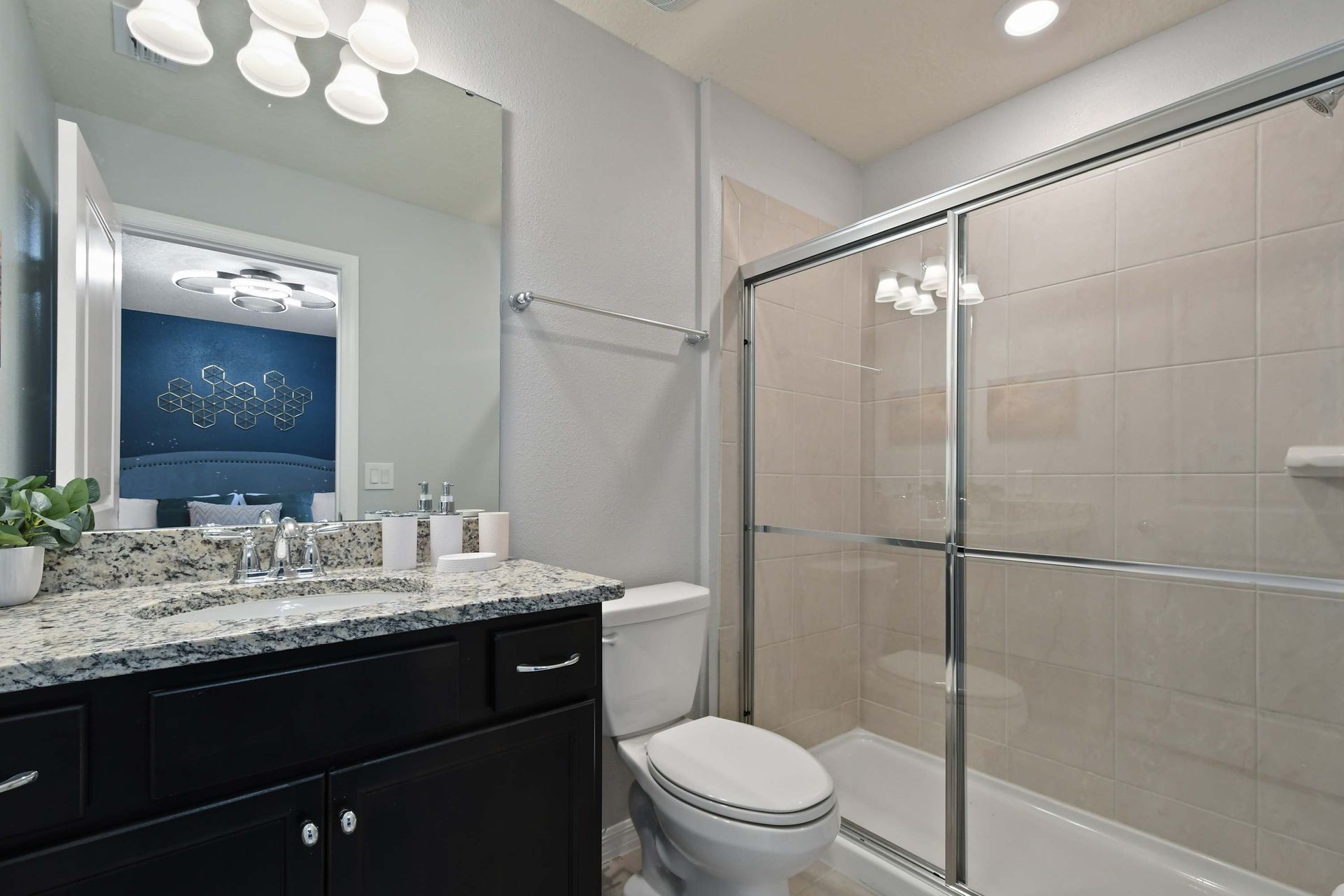 Stylish ensuite bath with granite counters and a spacious walk-in glass shower.