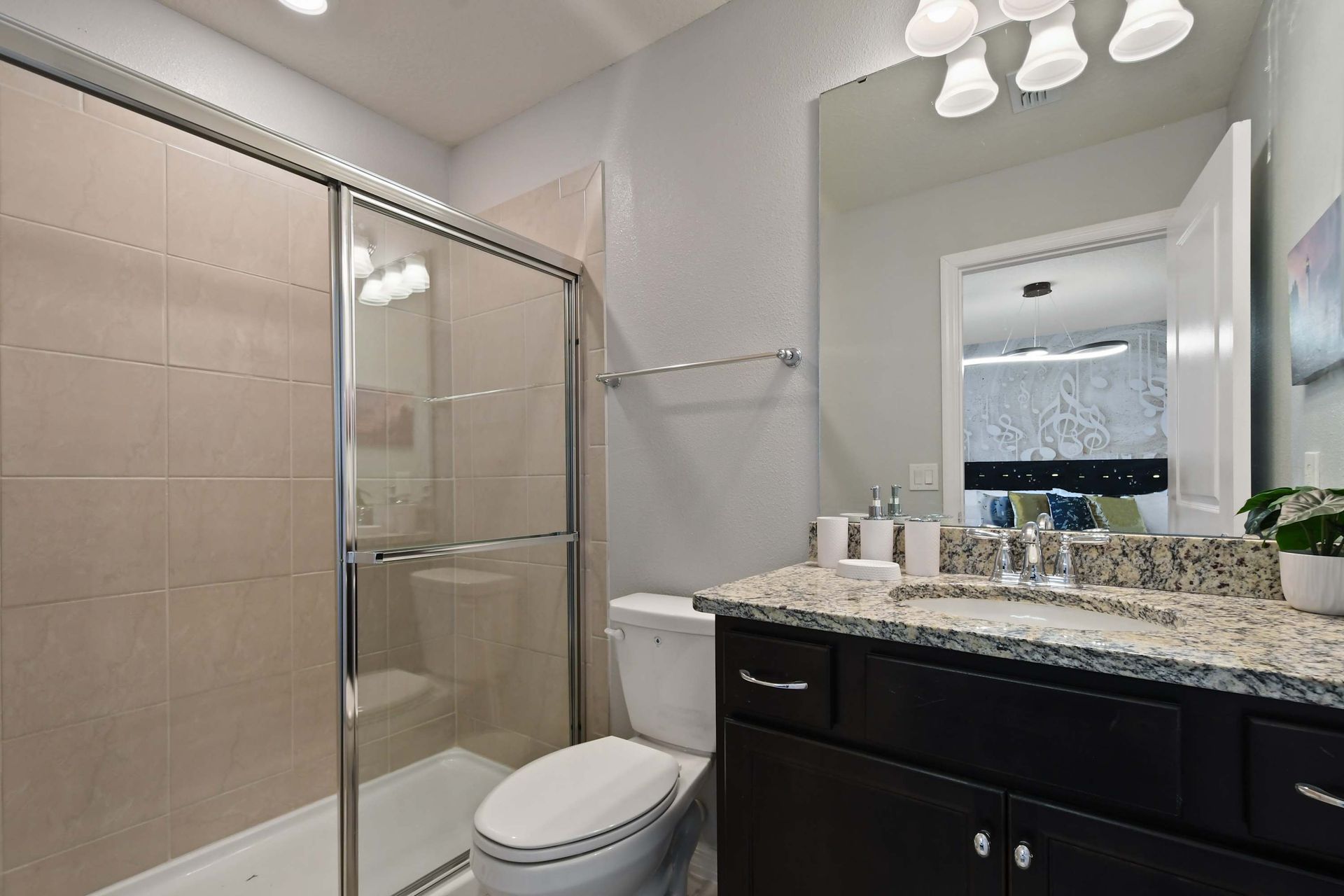 Sleek ensuite with granite vanity, modern fixtures, and a spacious glass shower.