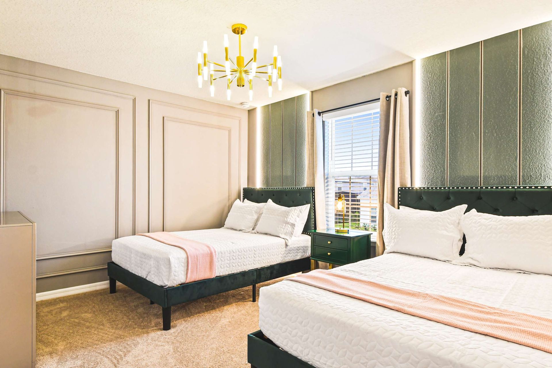 Elegant bedroom with twin beds, gold accents, and soft lighting for a cozy stay.