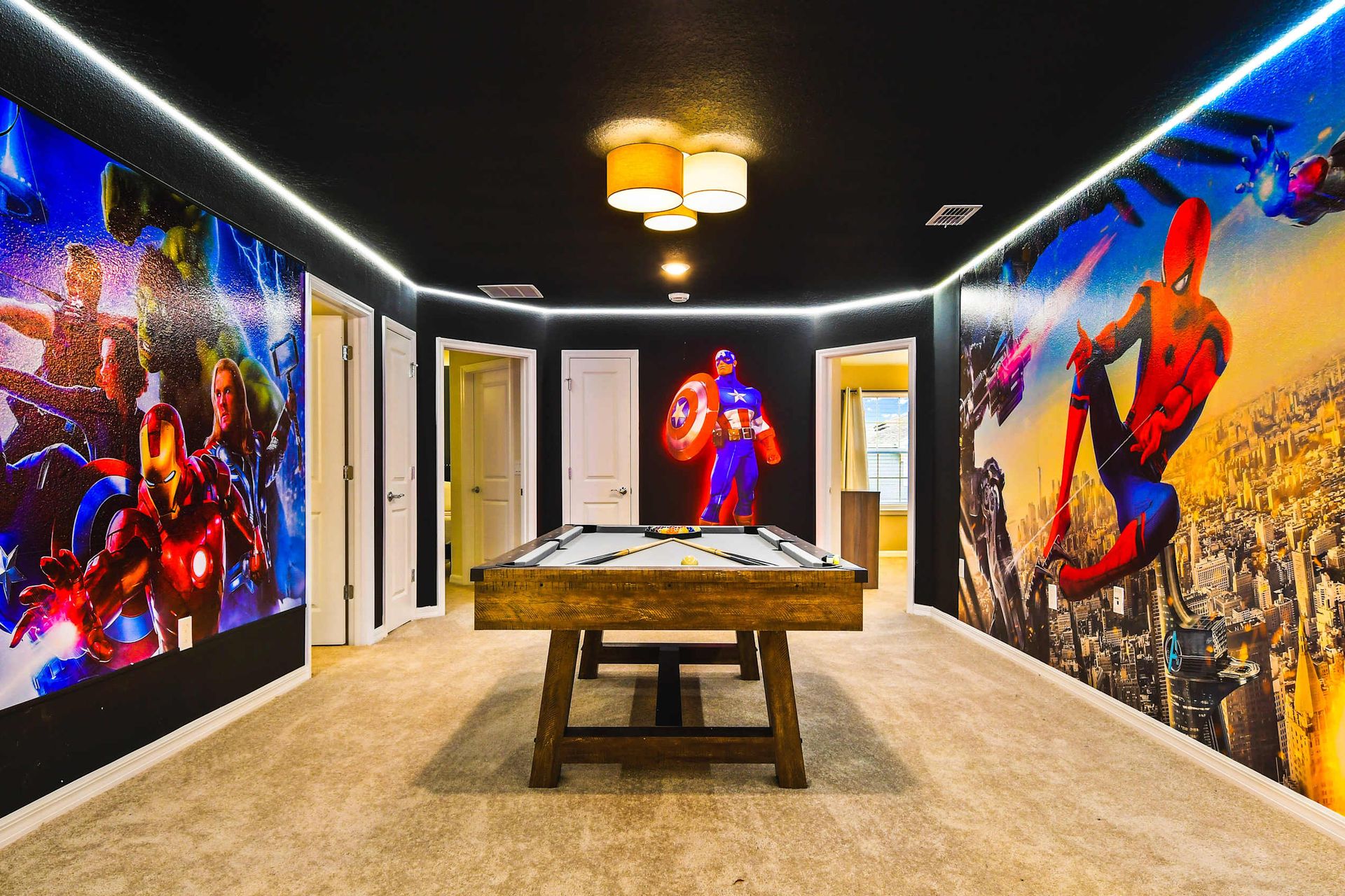 Marvel-themed game room with bold murals and a pool table for heroic hangouts.