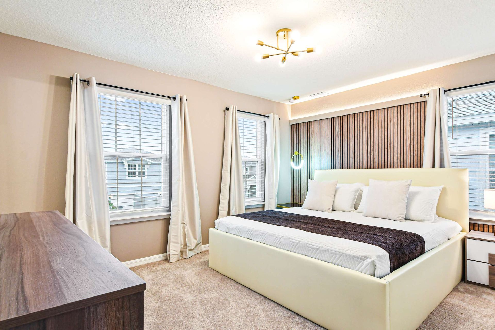 Modern bedroom with soft tones, sleek wood accents, and a king-sized bed for comfort.