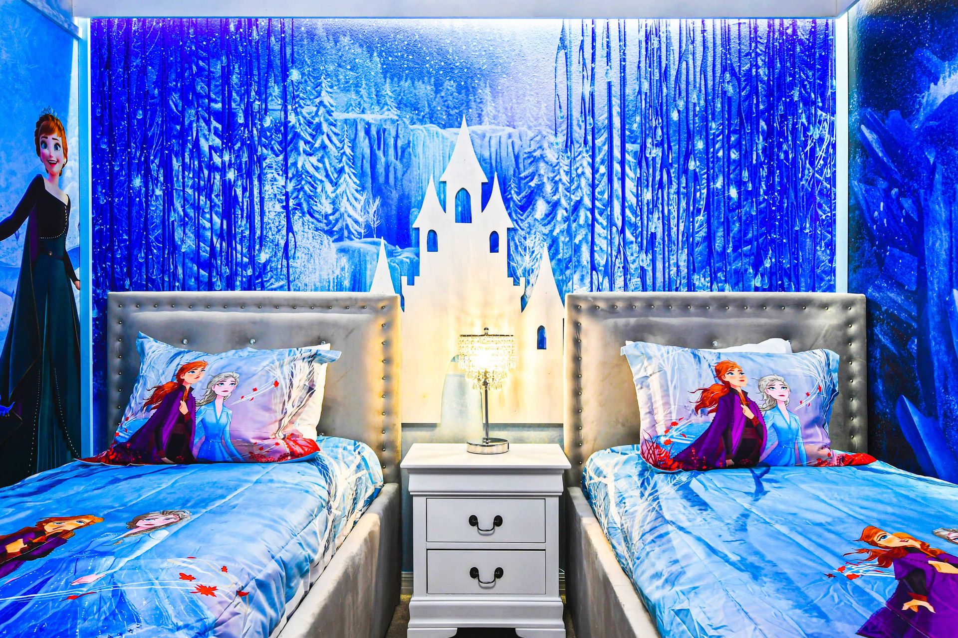 Frozen-themed bedroom with twin beds, icy murals, and cozy decor for a magical stay.