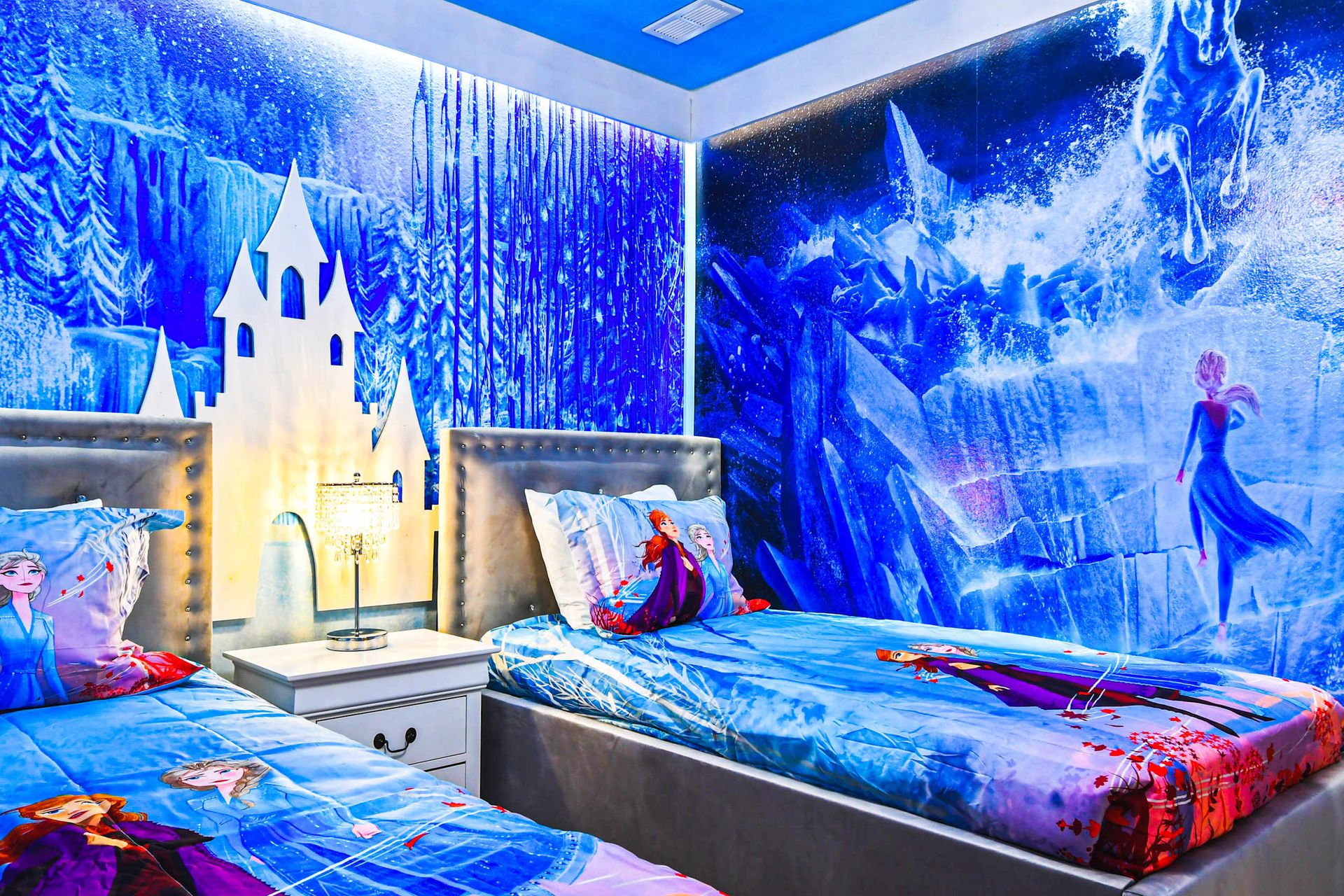 Frozen-themed bedroom with icy murals and twin beds for a magical escape.