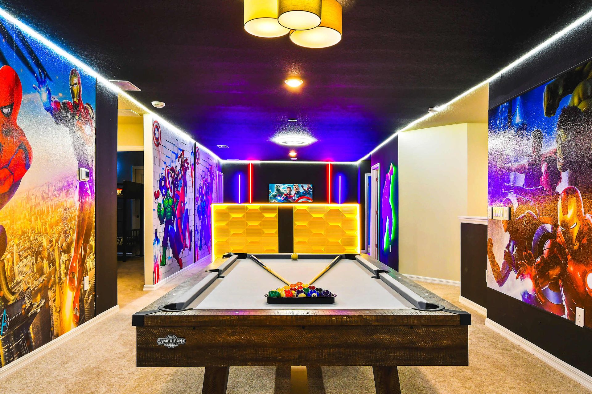Marvel-themed game room with bold murals and a pool table for heroic hangouts.