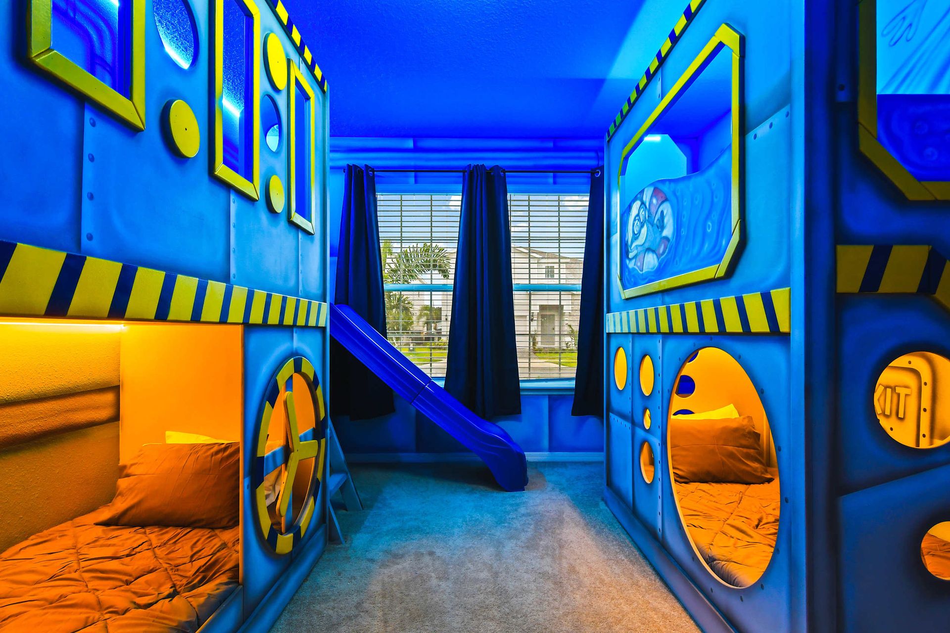 Submarine-themed bunk room with slides and cozy pods for an underwater adventure.