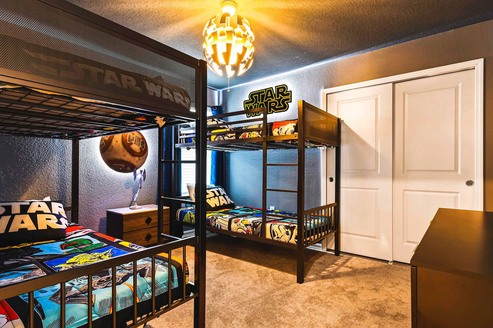 Star Wars-themed bunk room with cozy beds, themed lighting, and galactic decor.