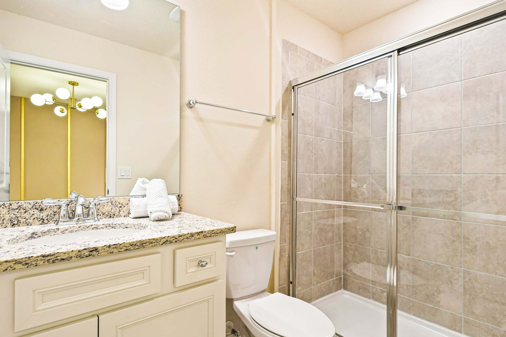 Stylish bathroom with granite double sinks, large shower, and sleek modern design
