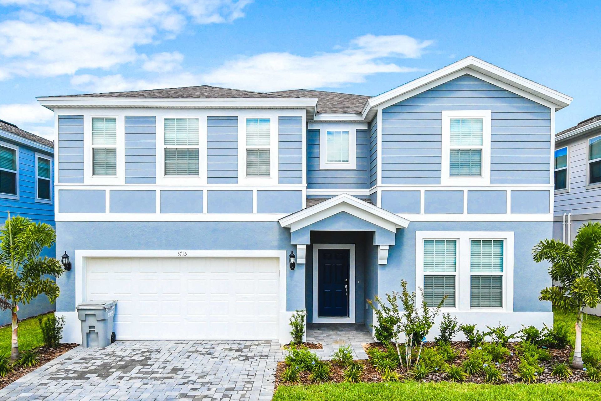 Spacious coastal-style home with modern design and lush landscaping.
