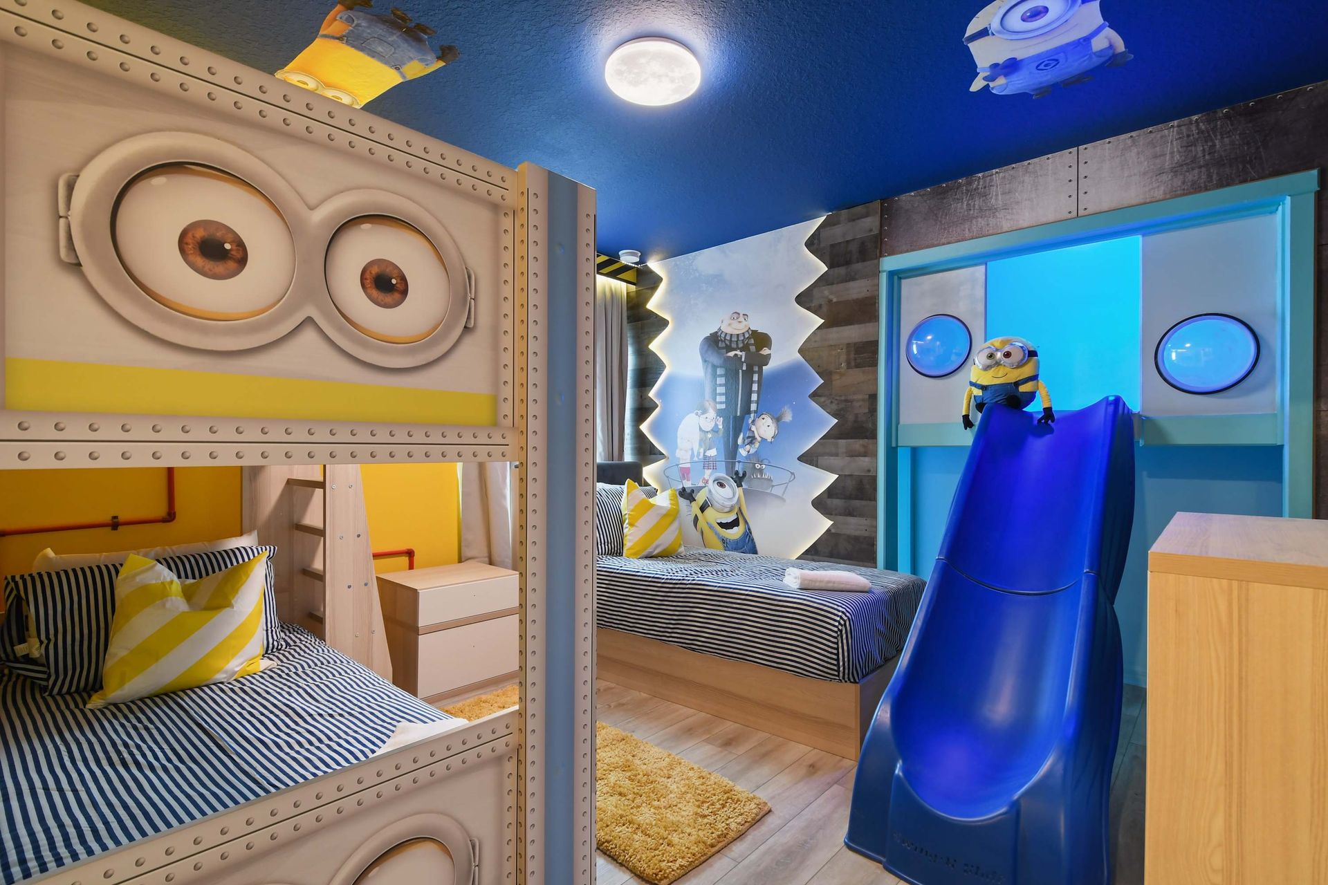 Minion-themed kids’ room with bunk beds, slide, and playful immersive design.