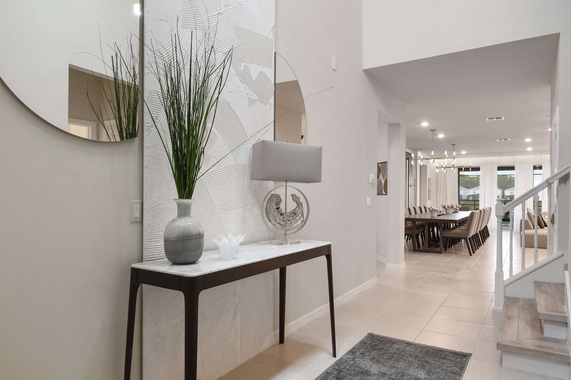 Stylish entryway with modern decor, textured walls, and a view into dining area.