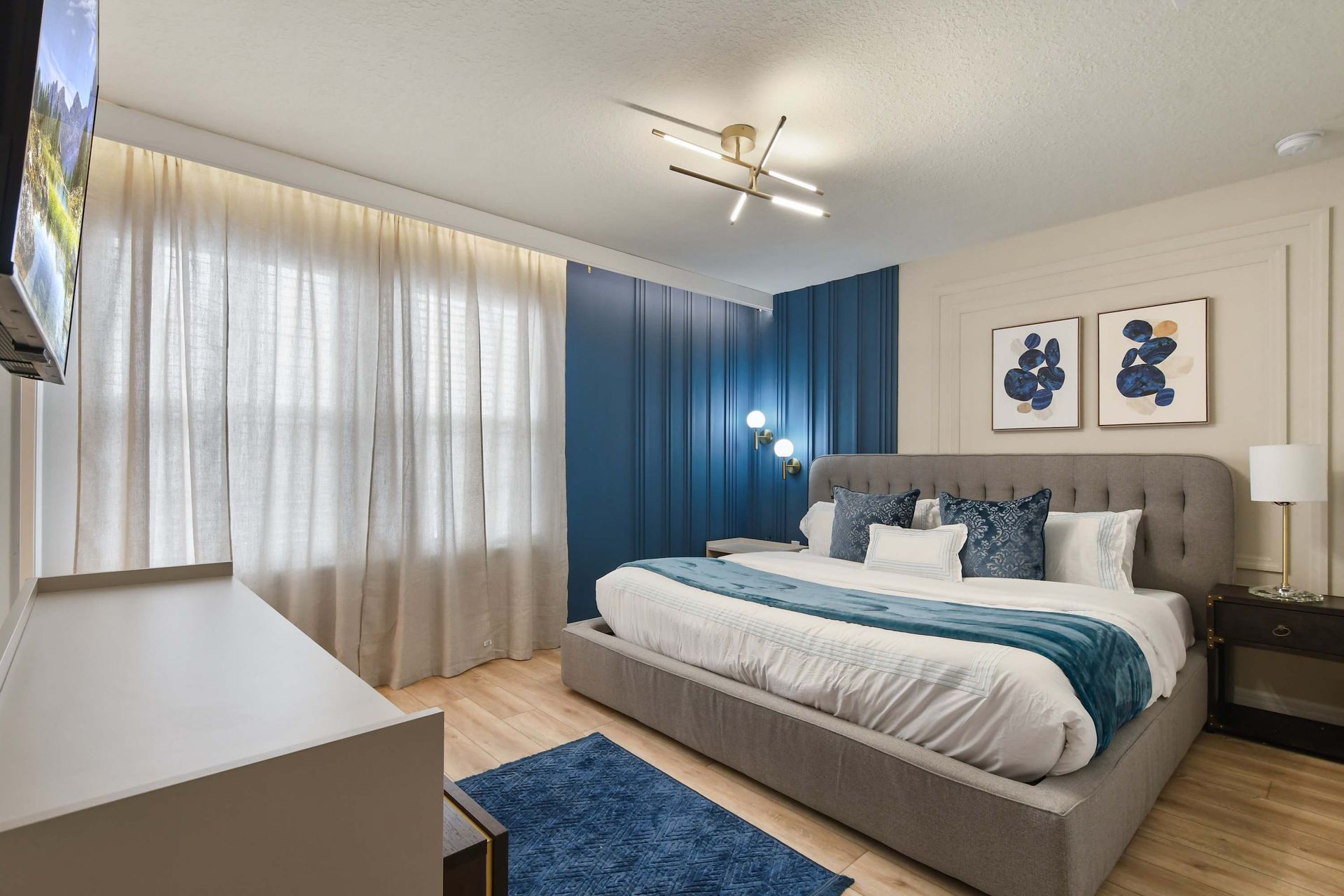 Chic modern bedroom with bold blue accents, plush king bed, and cozy lighting.