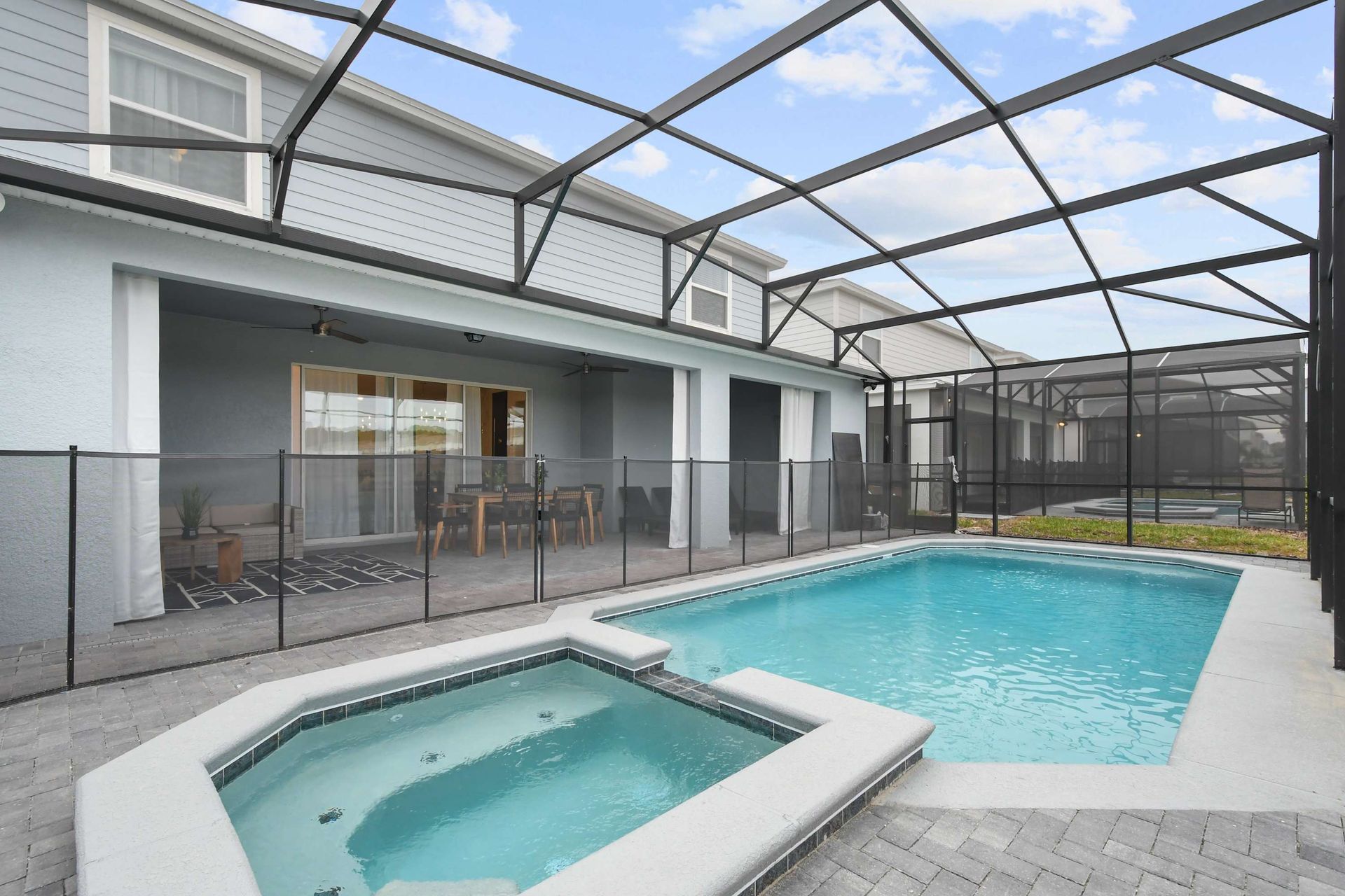 Private screened pool and spa with covered patio, outdoor dining, and lounge space.