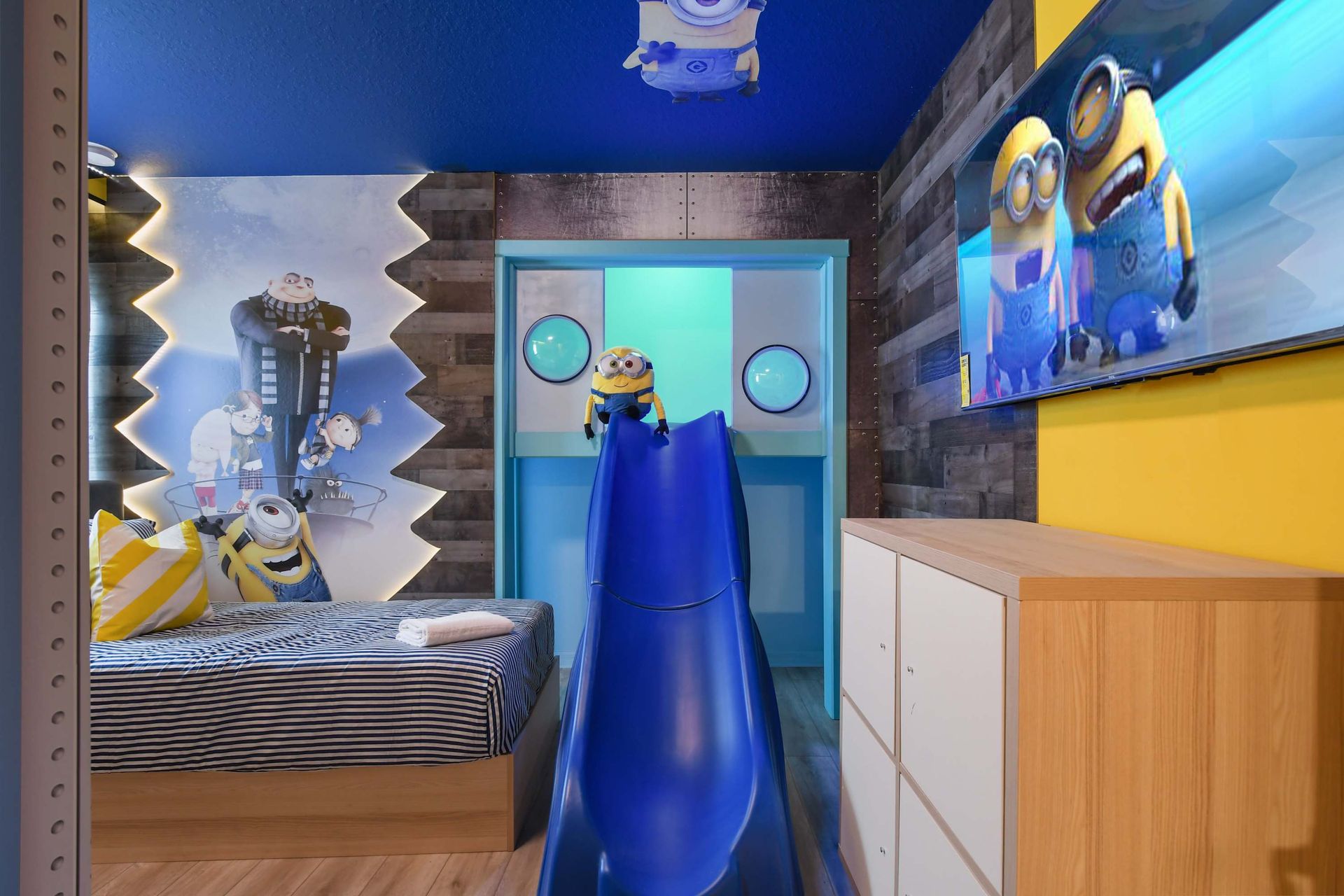 Minions-themed kids' room with slide, Gru mural, and a vibrant, playful setup.