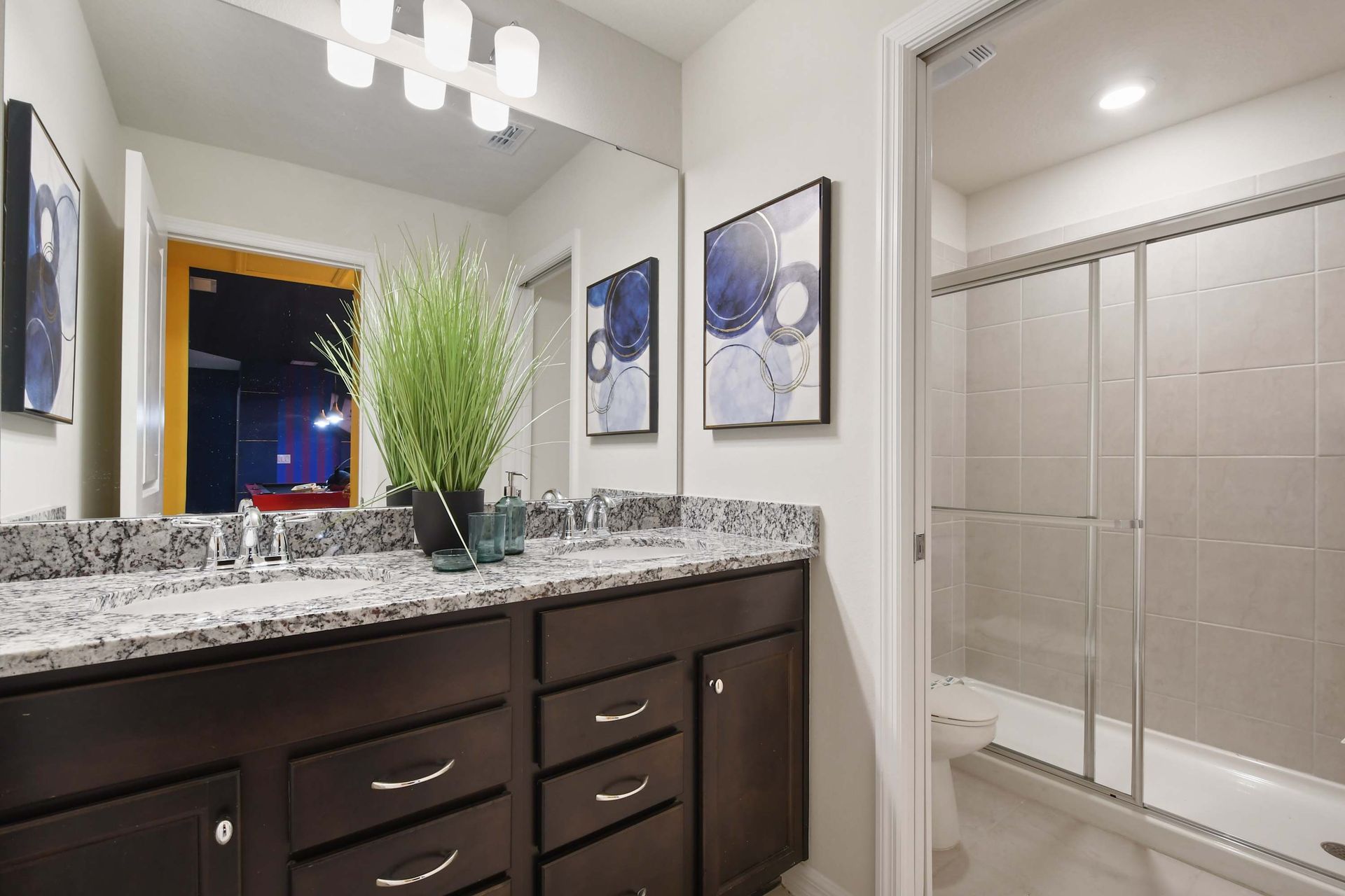 Contemporary bathroom with granite counters, double sinks, and walk-in shower.