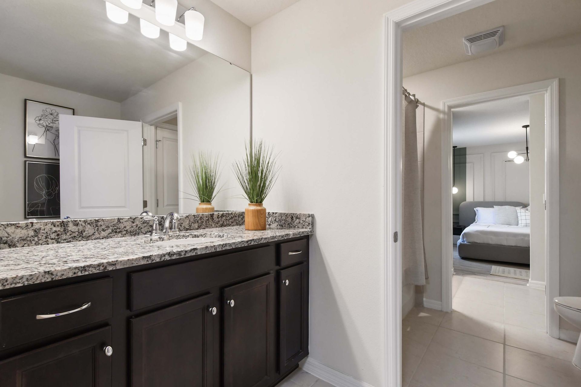 Bright bathroom with granite vanity, stylish decor, and direct access to bedroom.
