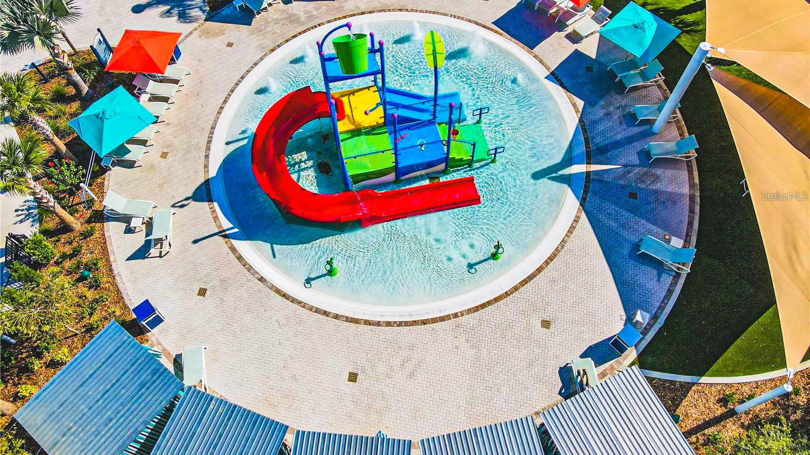 Colorful splash pad with slides and loungers, perfect for kids’ fun under the sun
