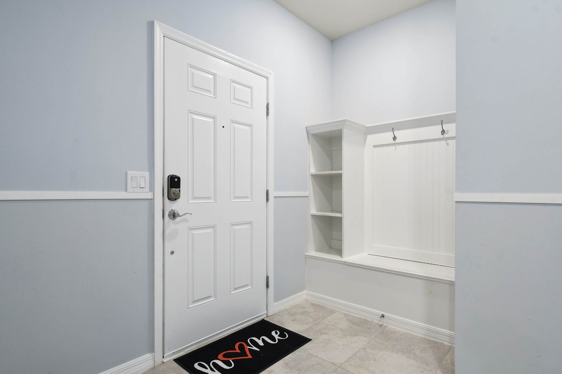 Inviting entryway with smart lock, built-in bench, hooks, and storage cubbies.