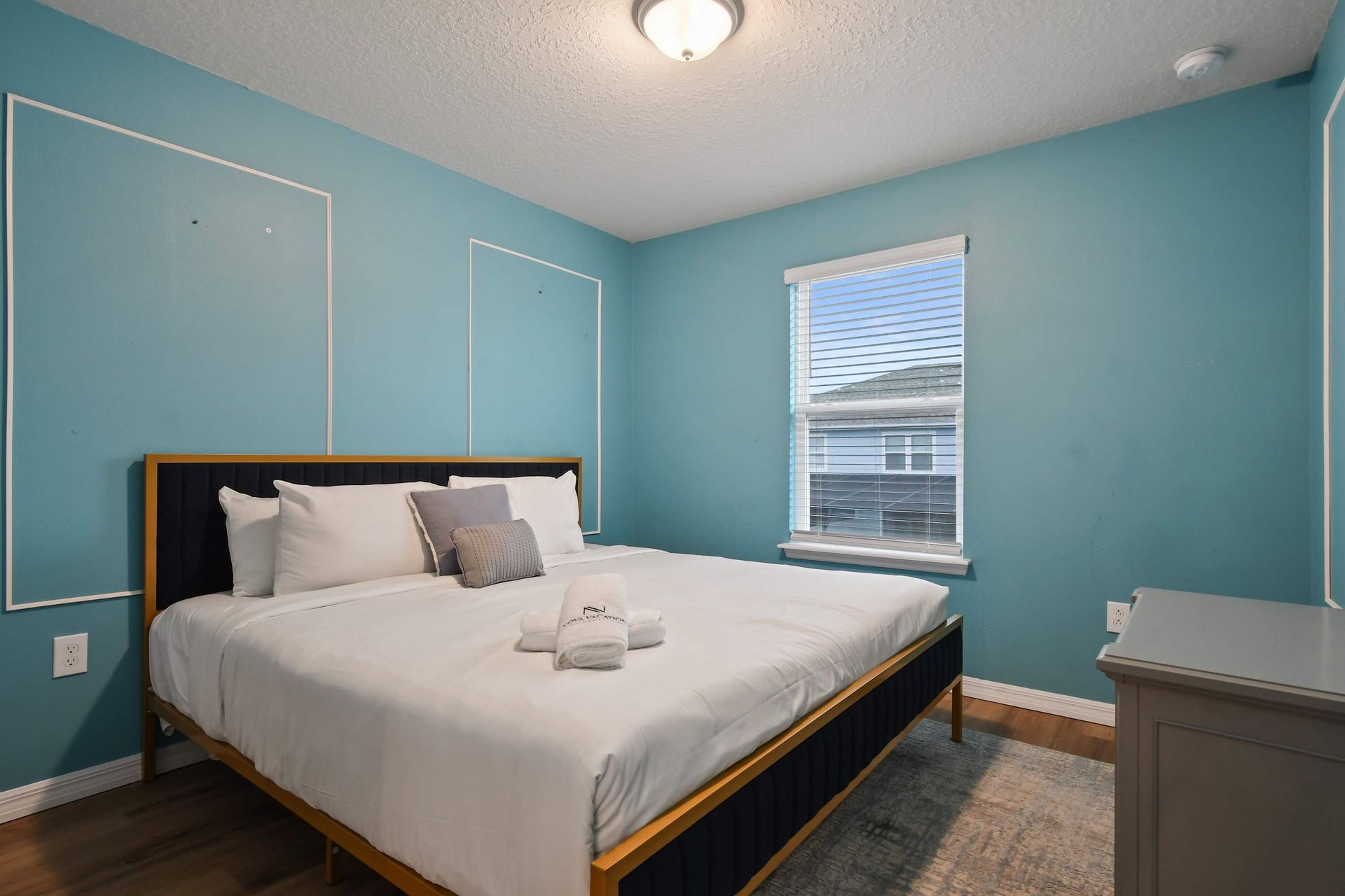 Cozy blue retreat with king bed, plush pillows, and bright natural light.