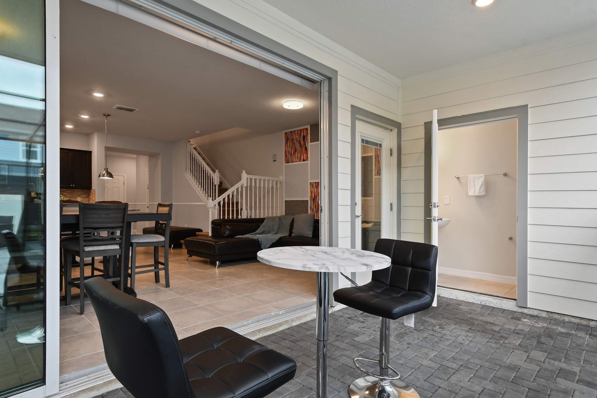 Seamless indoor-outdoor space with patio seating and private poolside access.