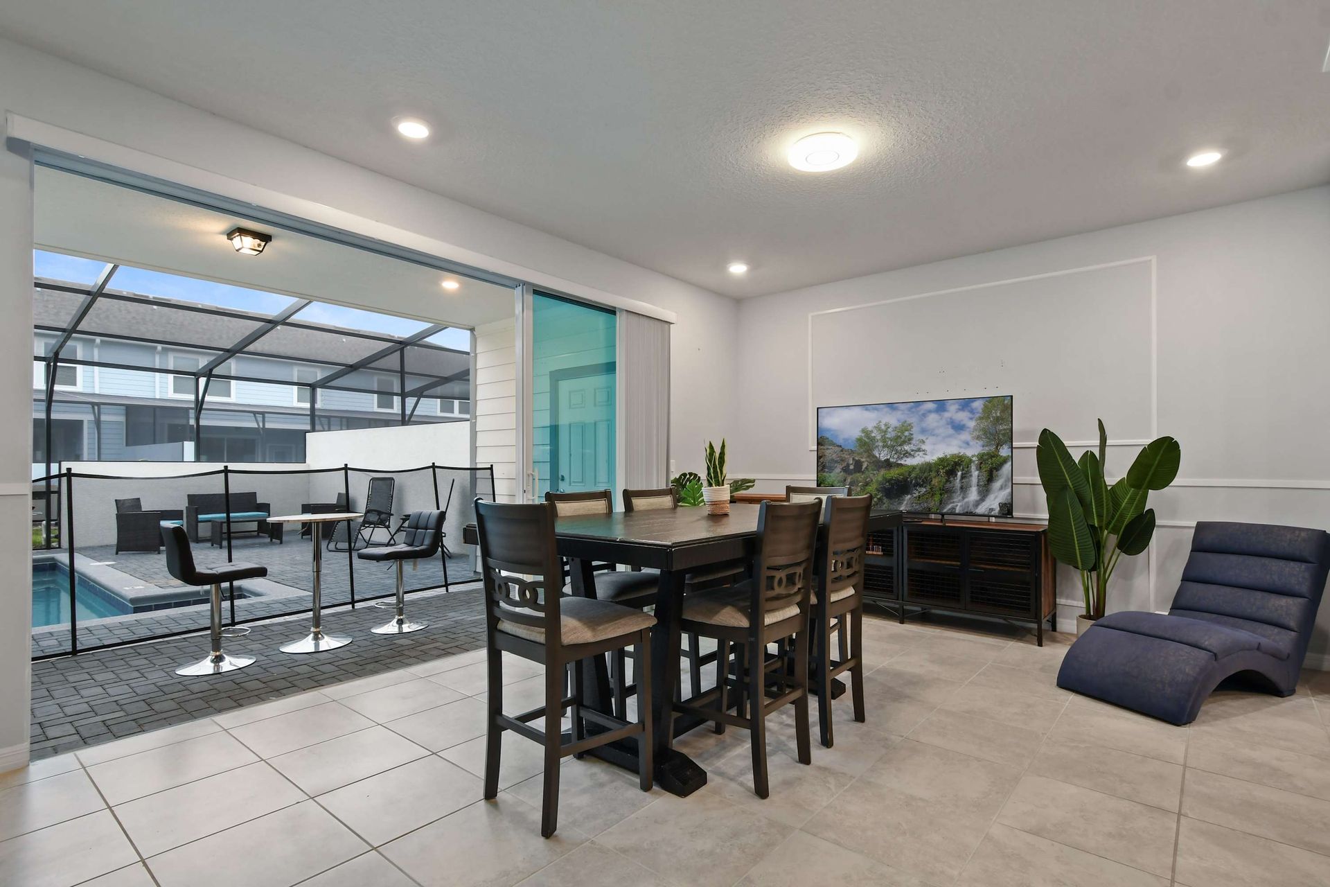 Indoor-outdoor lounge with TV, dining, and poolside seating for full relaxation.