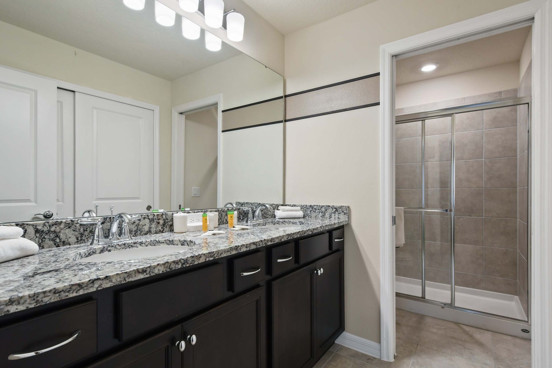 Spacious bathroom with double sinks, granite counters, and a walk-in shower.