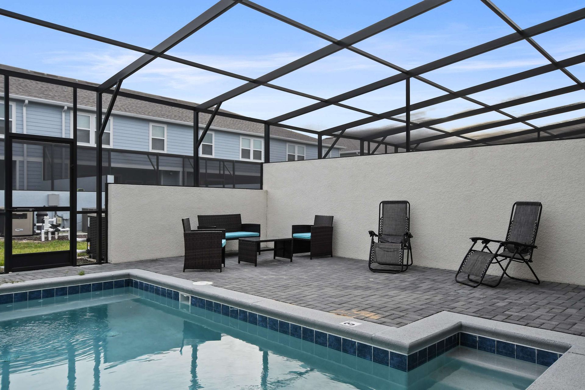 Relax in the private screened pool area with lounge chairs and outdoor seating.