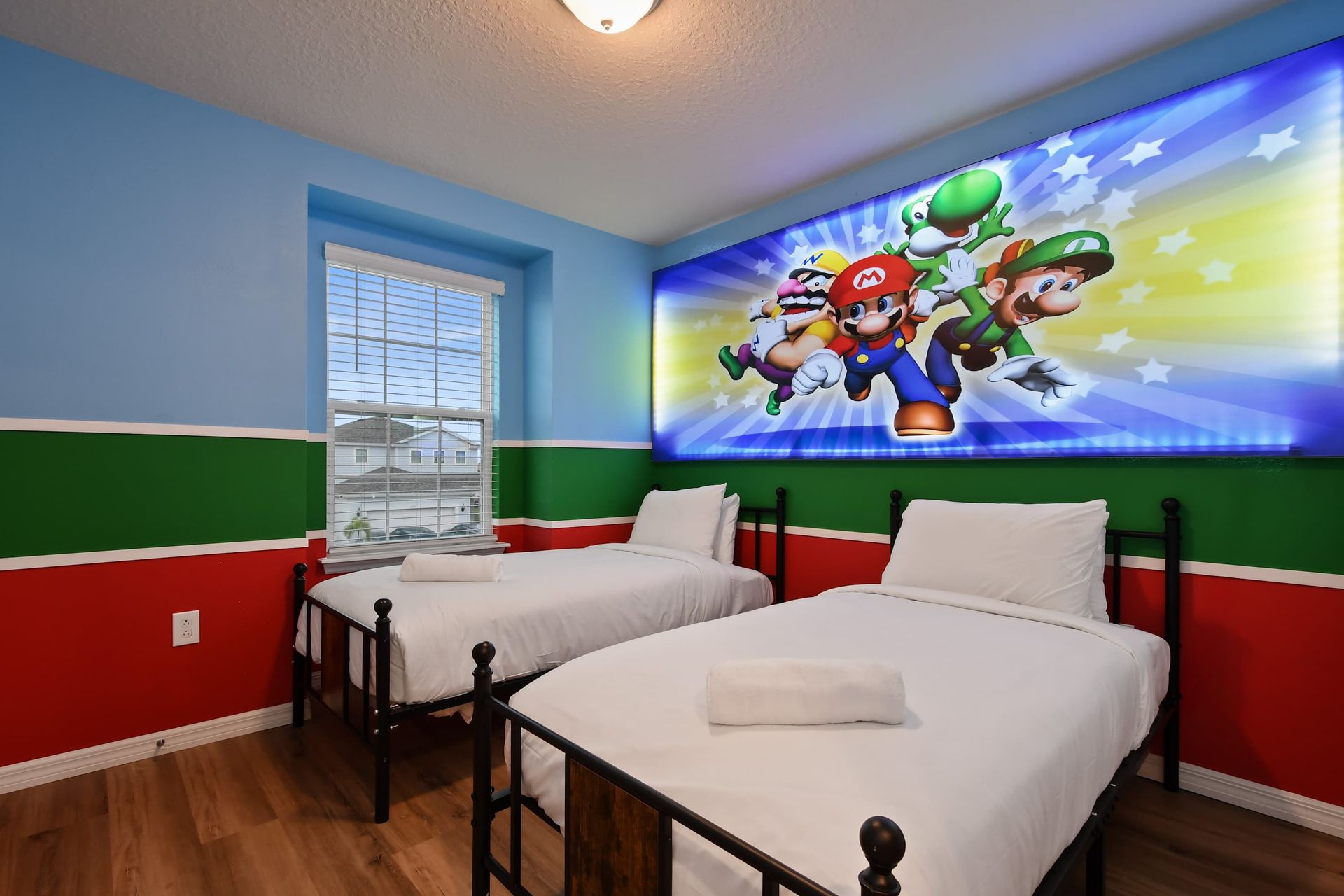Vibrant game-themed room with twin beds, bold colors, and playful energy.