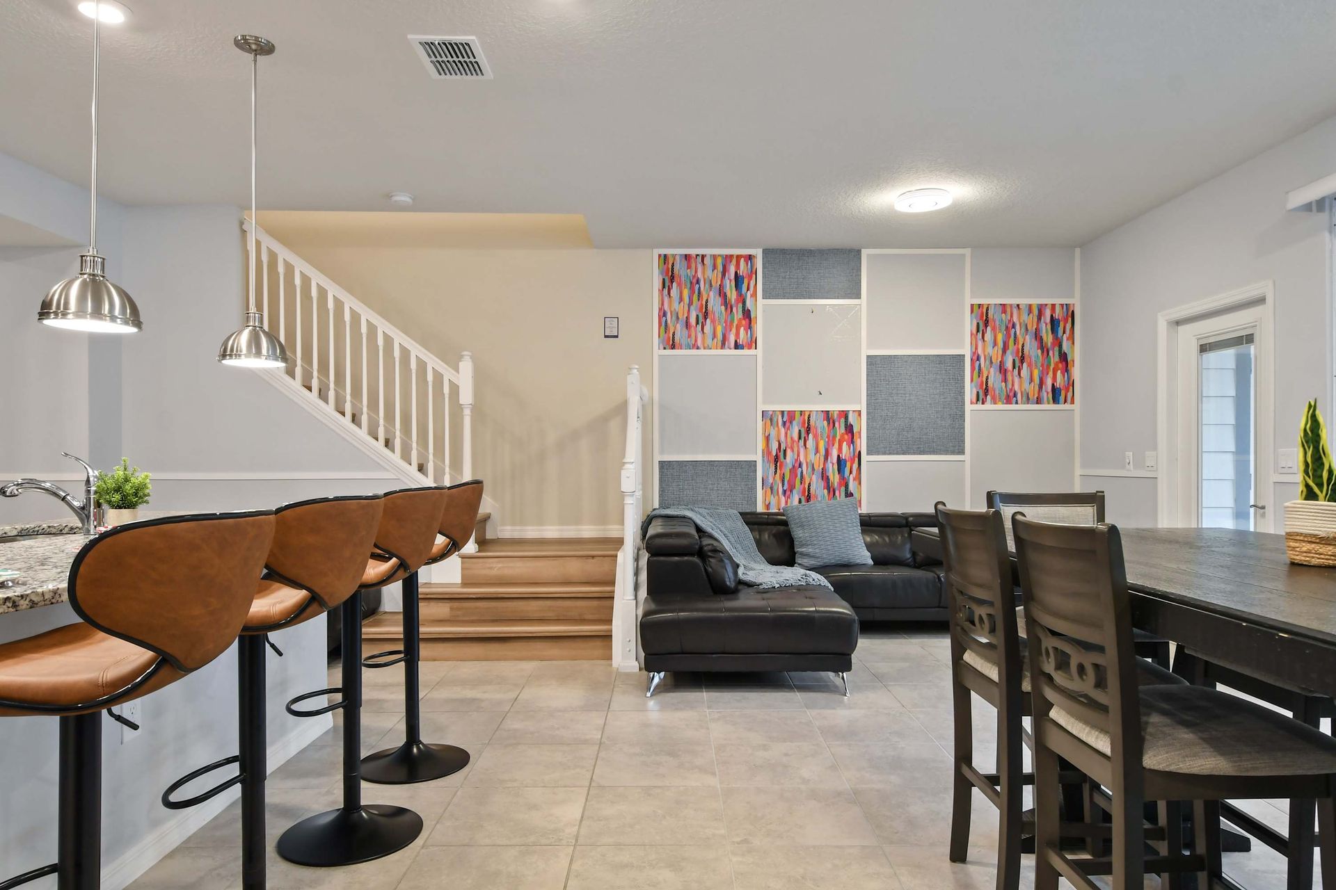 Colorful modern living space with sleek bar seating and a cozy sectional lounge.