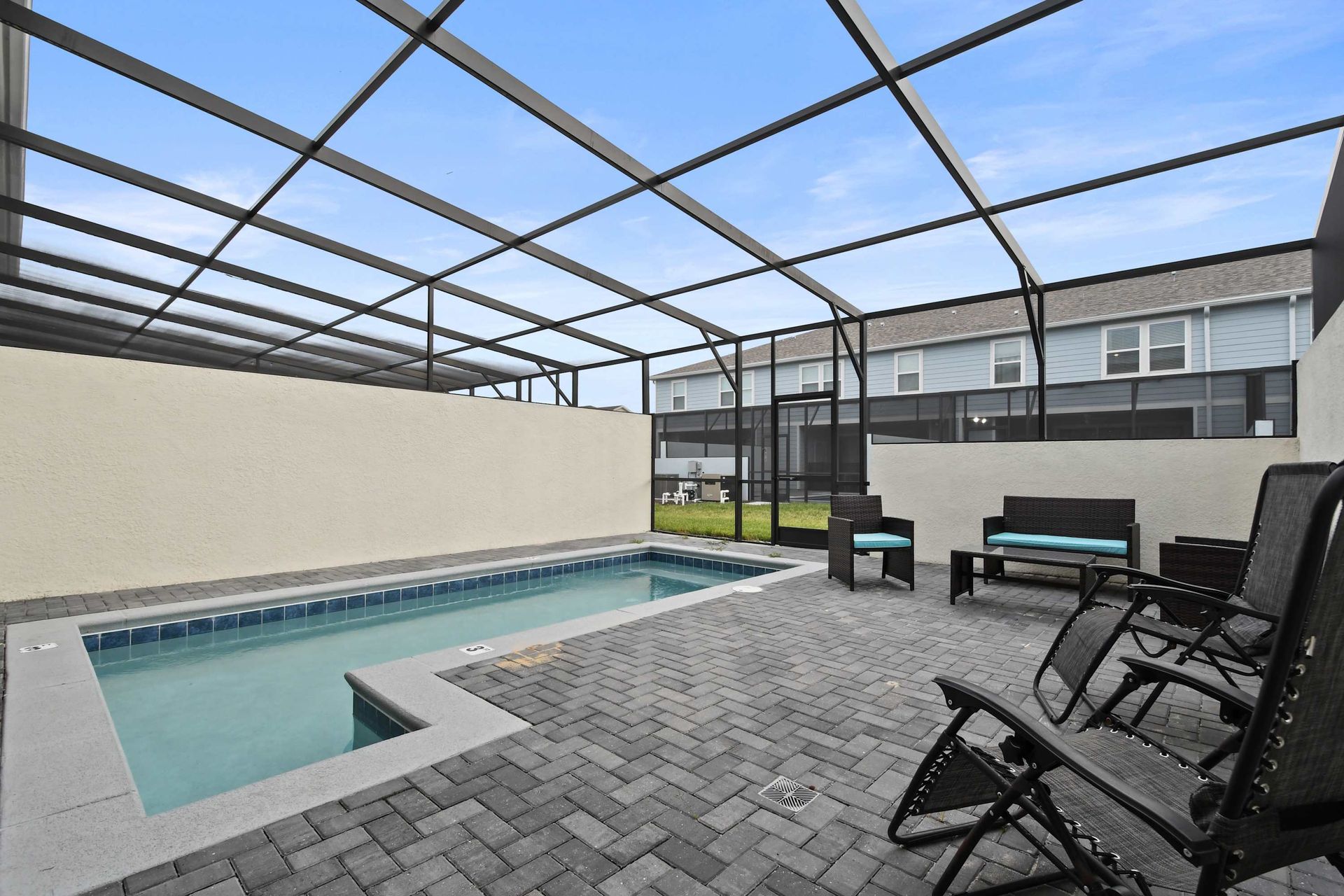 Private screened-in pool with lounge chairs, cozy seating, and sunny outdoor vibes.