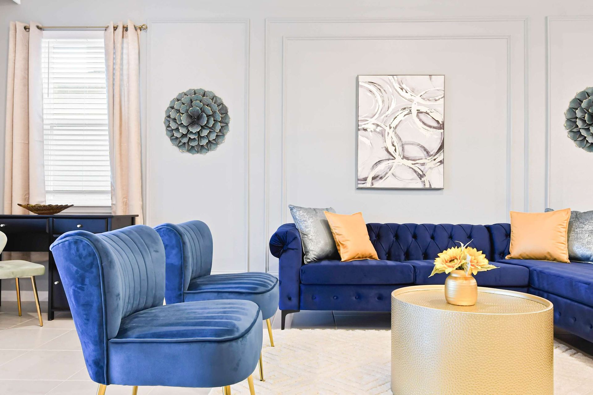 Chic living room with royal blue seating, gold accents, and elegant modern vibes.