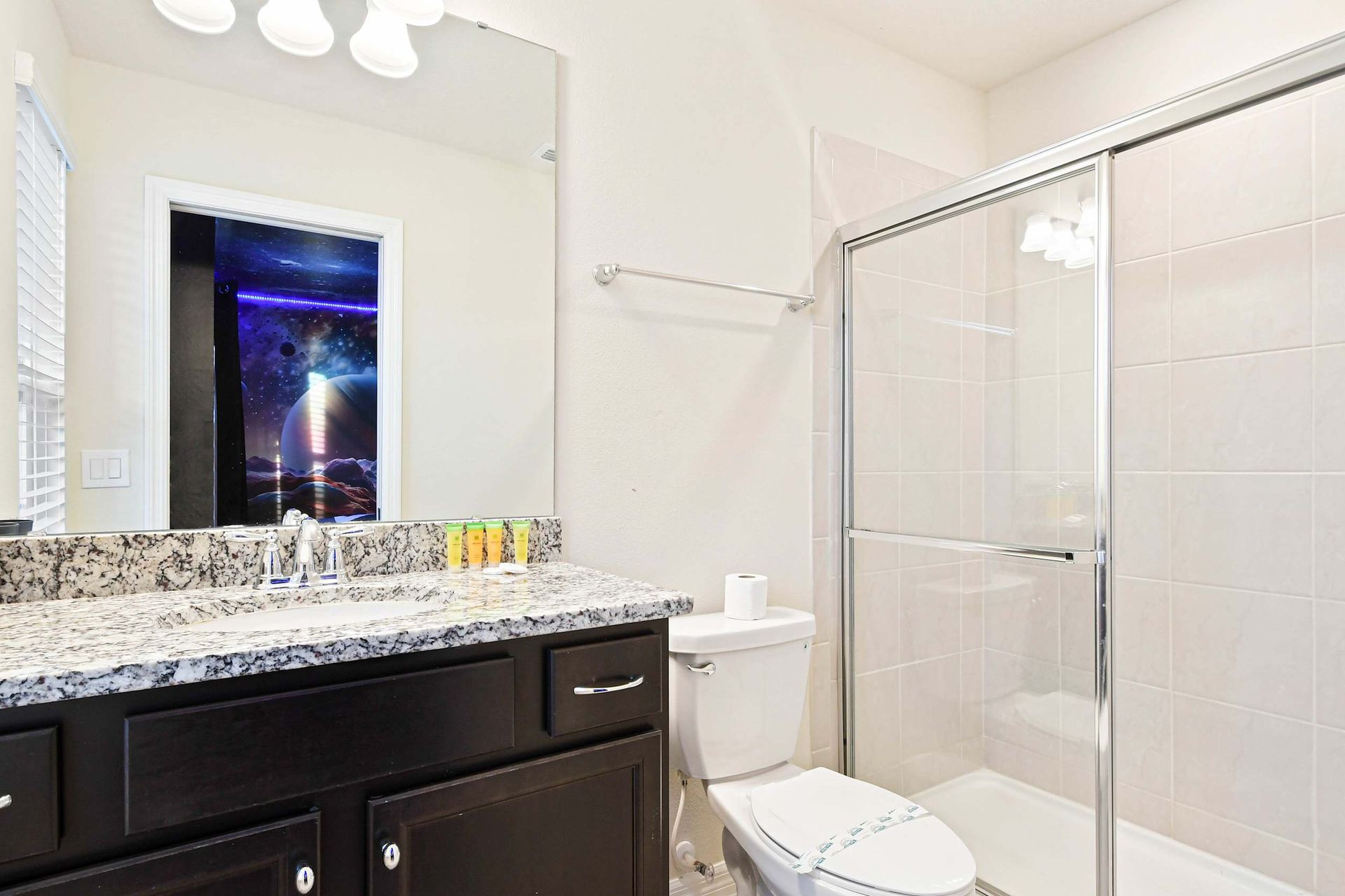 Modern bathroom with granite counters, walk-in shower, and galactic bedroom access.